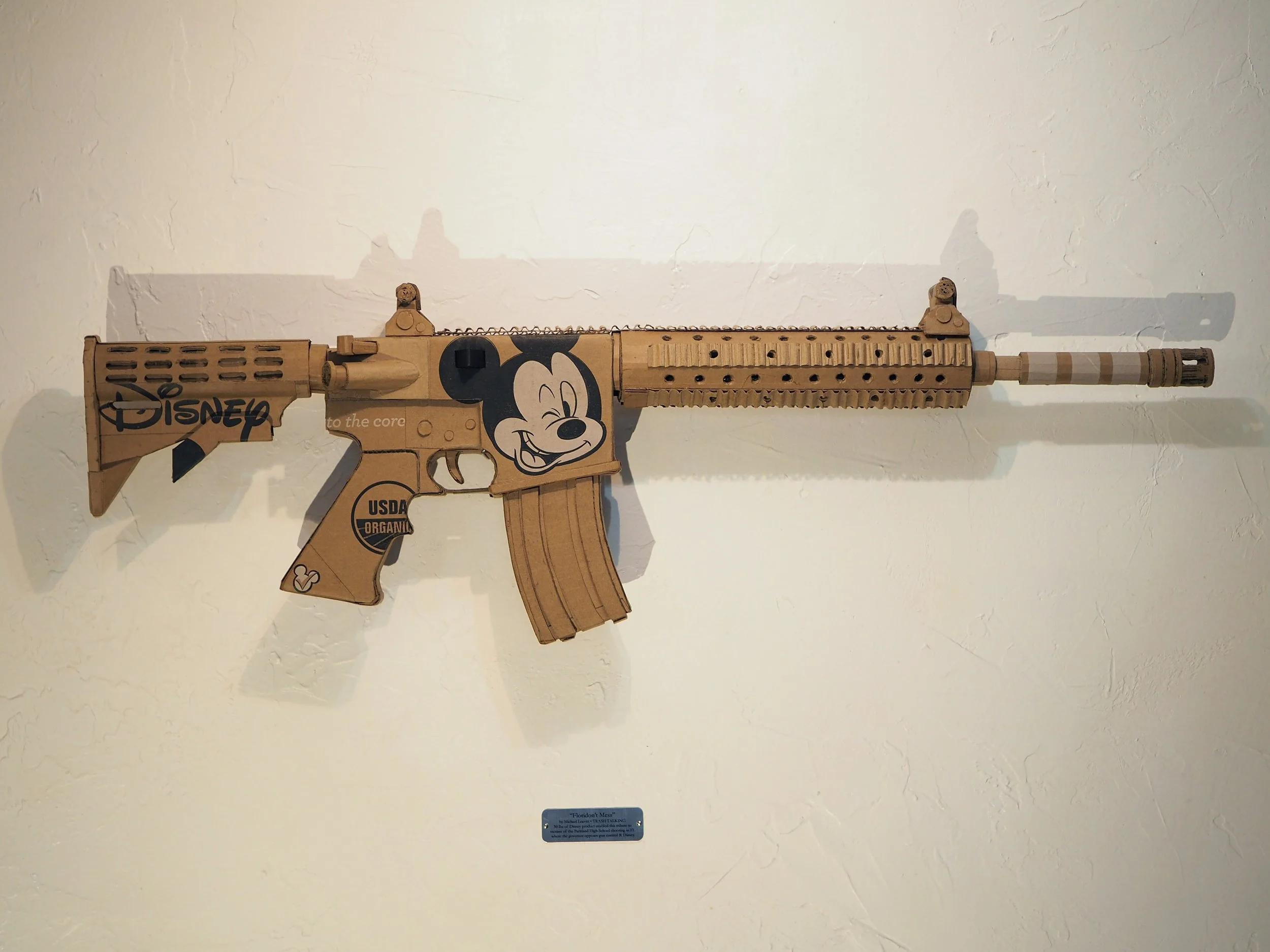 Disney Mickey Mouse satire Florida mass shooting cardboard recycled material art sculpture political action parody