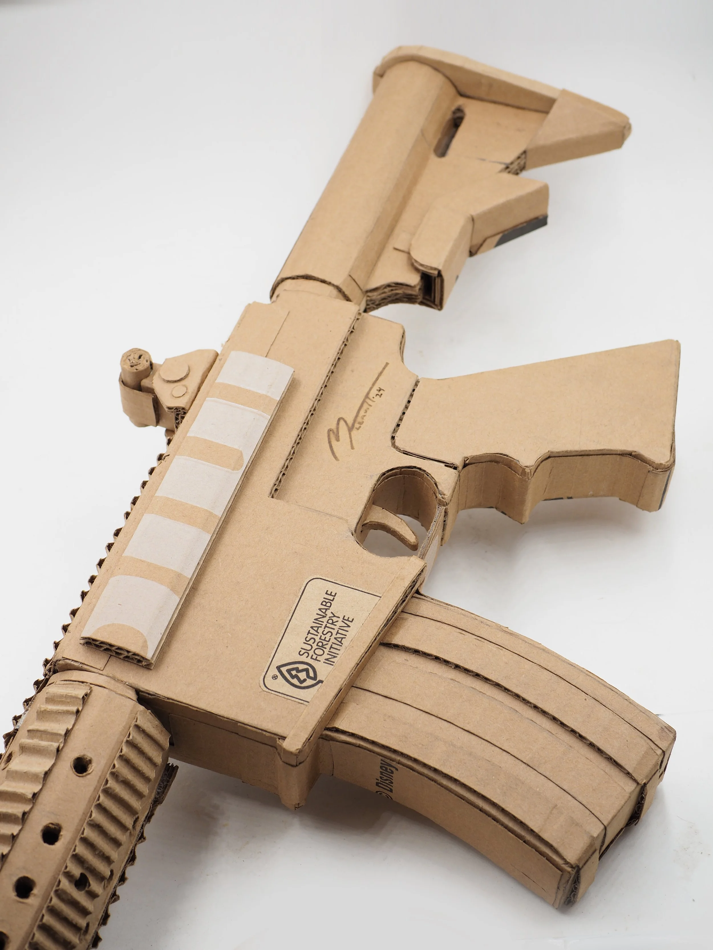 Disney satire Florida mass shooting cardboard recycled material art sculpture political action parody