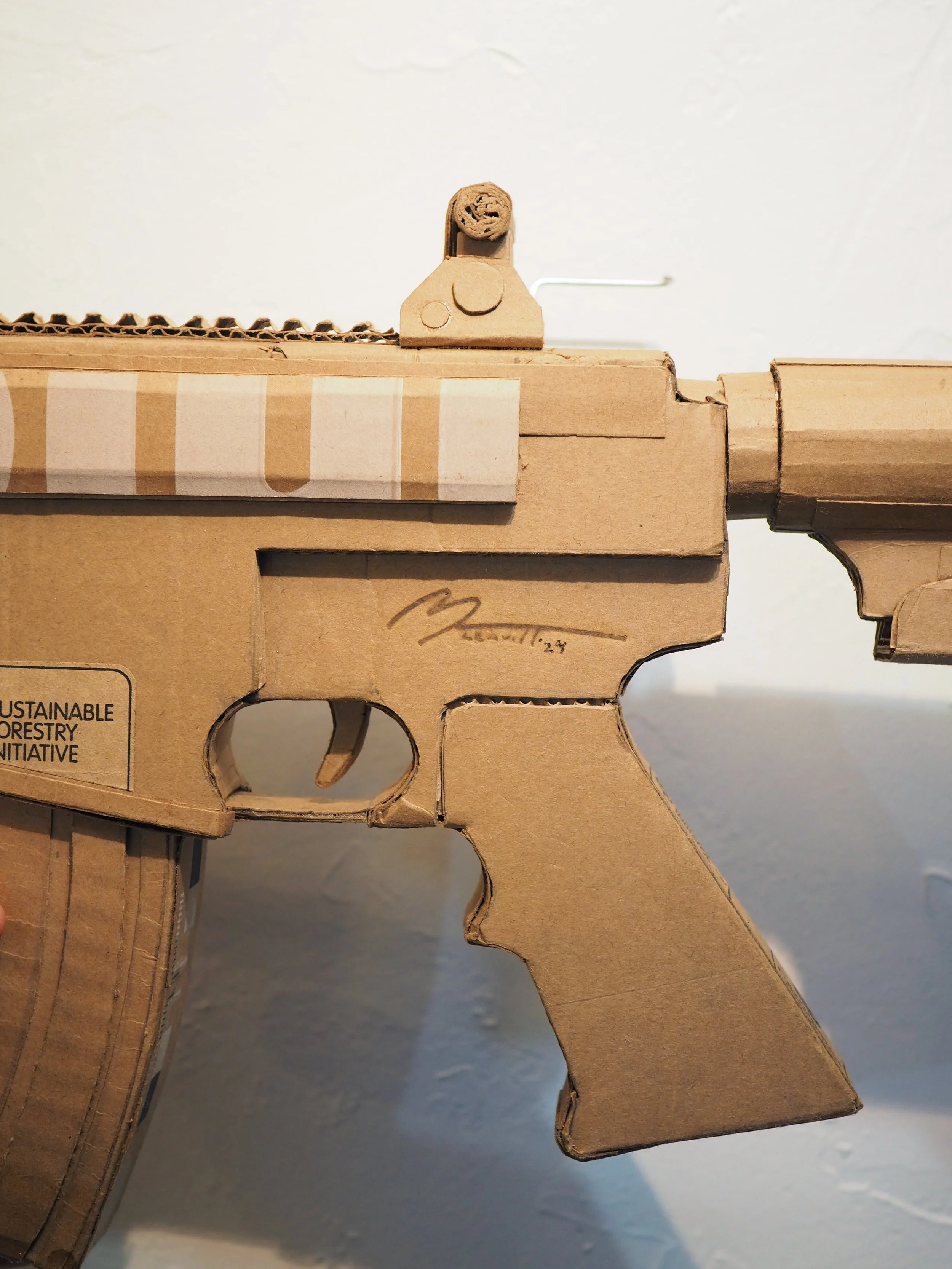 Disney satire Florida mass shooting cardboard recycled material art sculpture political action parody