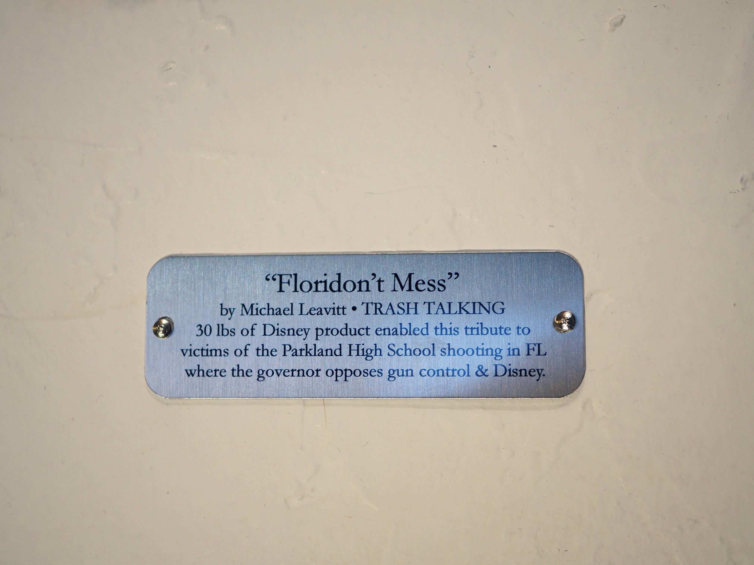 Disney satire Florida mass shooting cardboard recycled material art sculpture political action parody