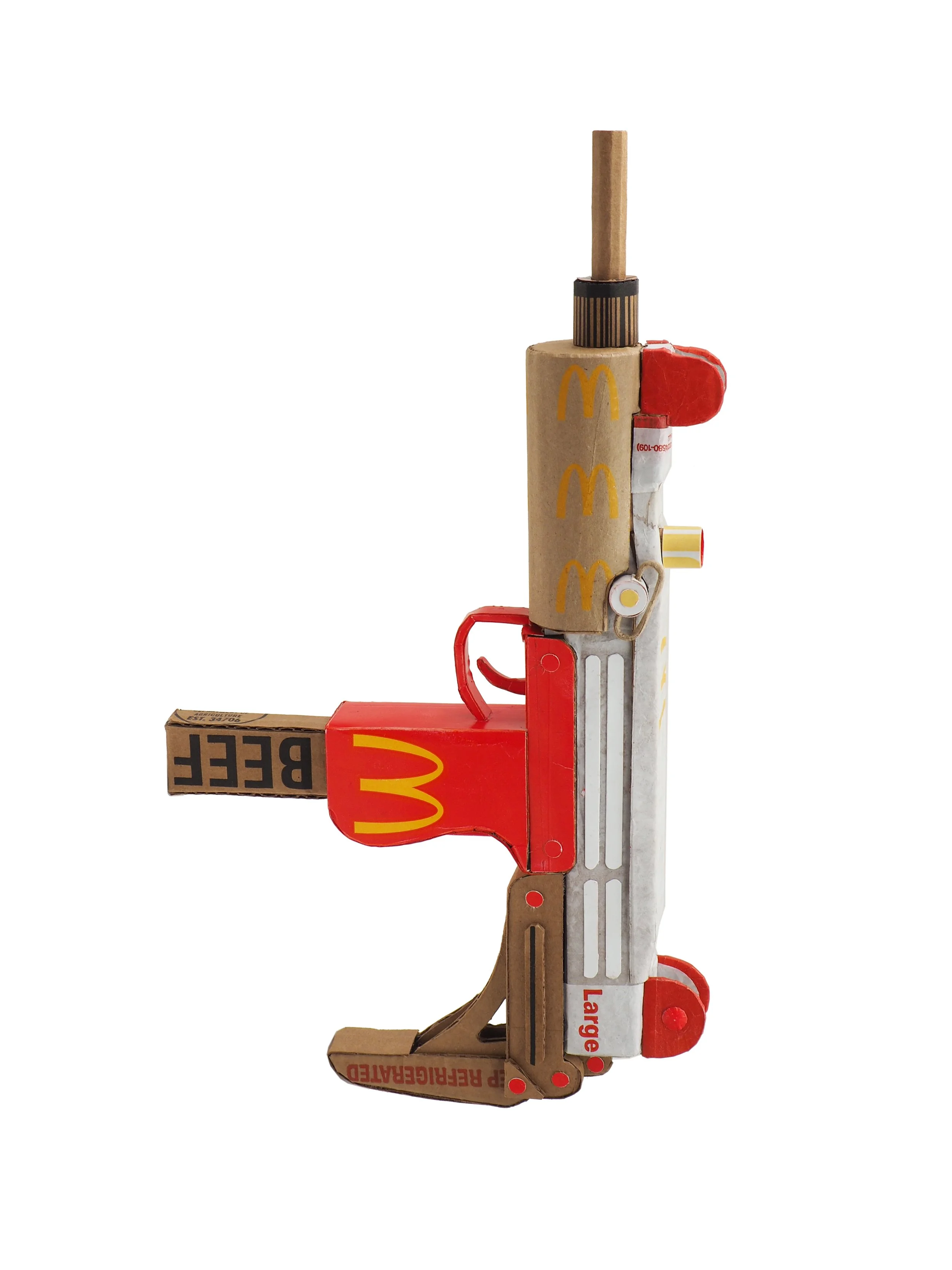 Mass shooting cardboard Uzi recycled material art sculpture political action McDonalds corporate culture parody