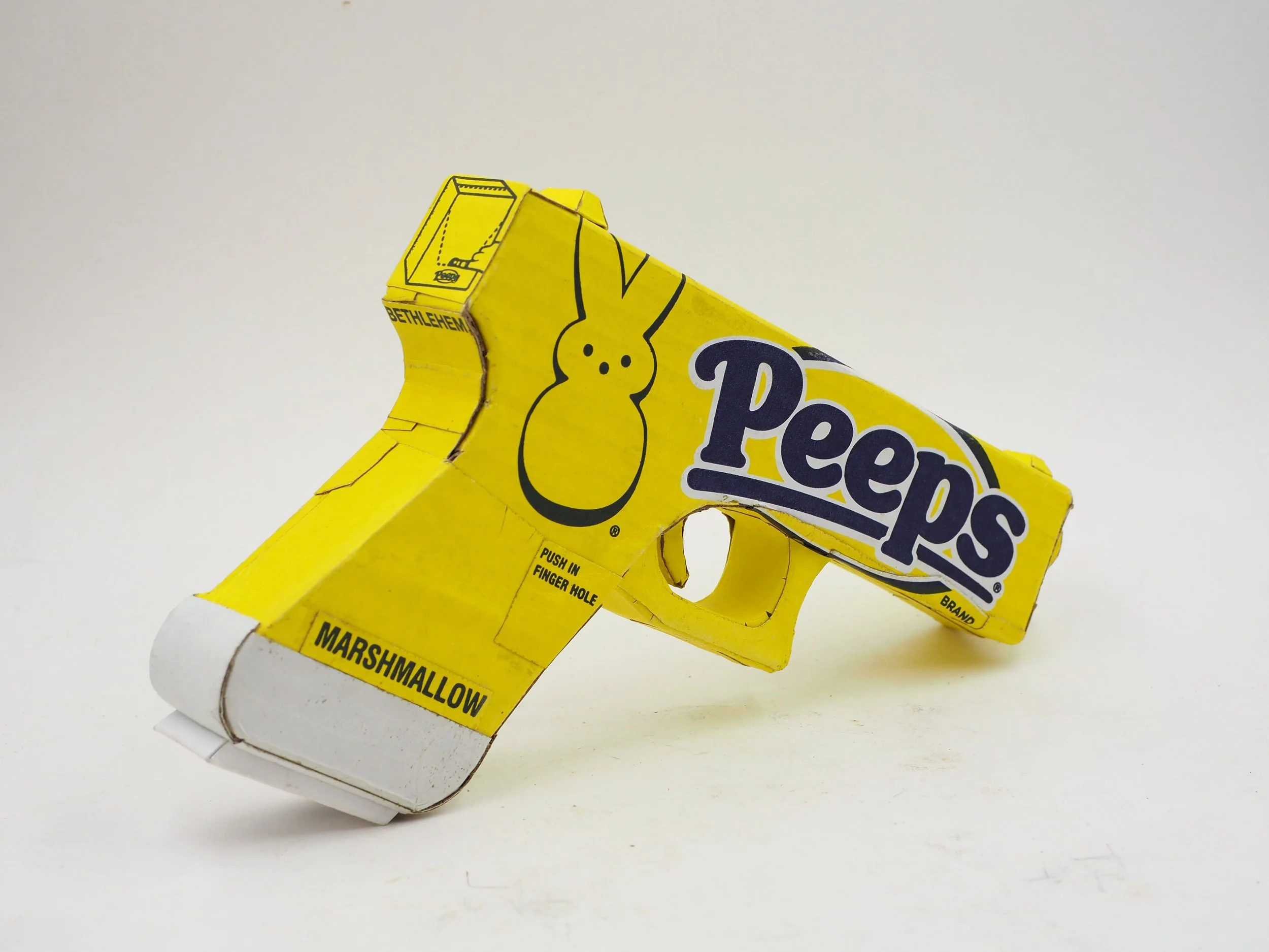 Mass shooting yellow marshmallow Easter candy peeps cardboard recycled material art sculpture political action satire
