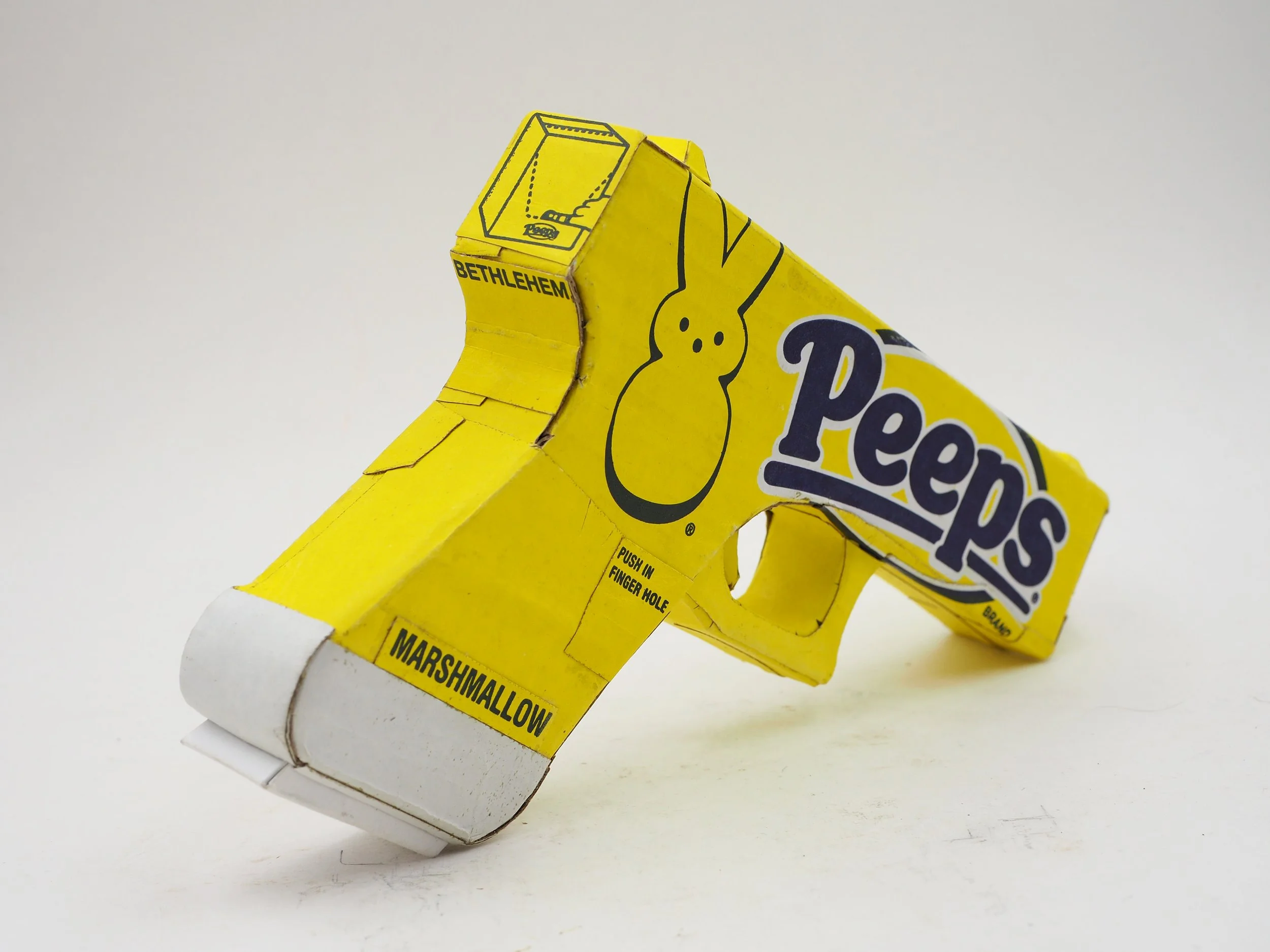 Mass shooting yellow marshmallow Easter candy peeps cardboard recycled material art sculpture political action satire