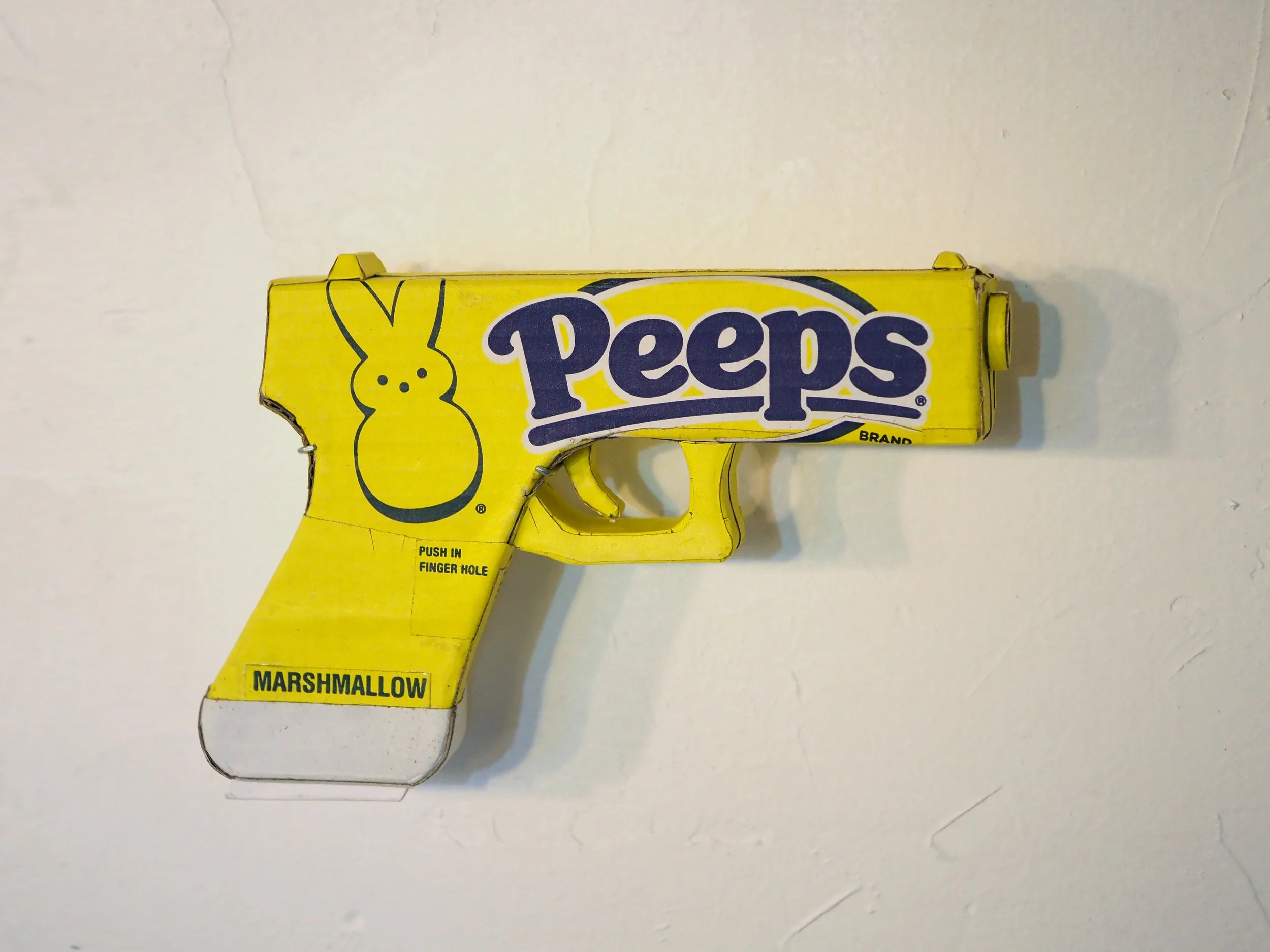 Mass shooting yellow marshmallow Easter candy peeps cardboard recycled material art sculpture political action satire