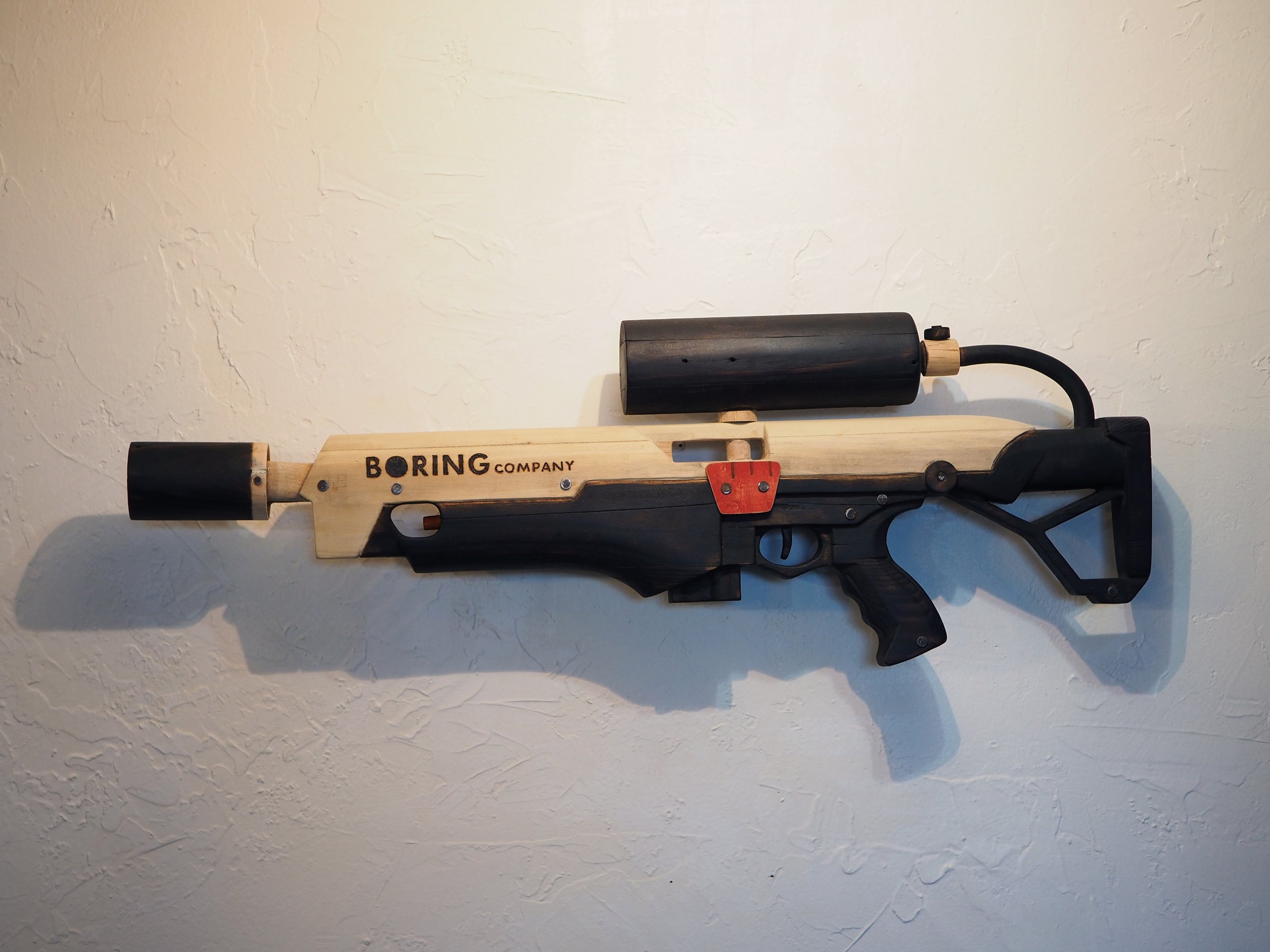 Elon Musk Boring Company flame thrower Twitter X Tesla corporate culture anti-capitalist woodworking wood sculpture recycled reclaimed pallet wood satire celebrity parody art