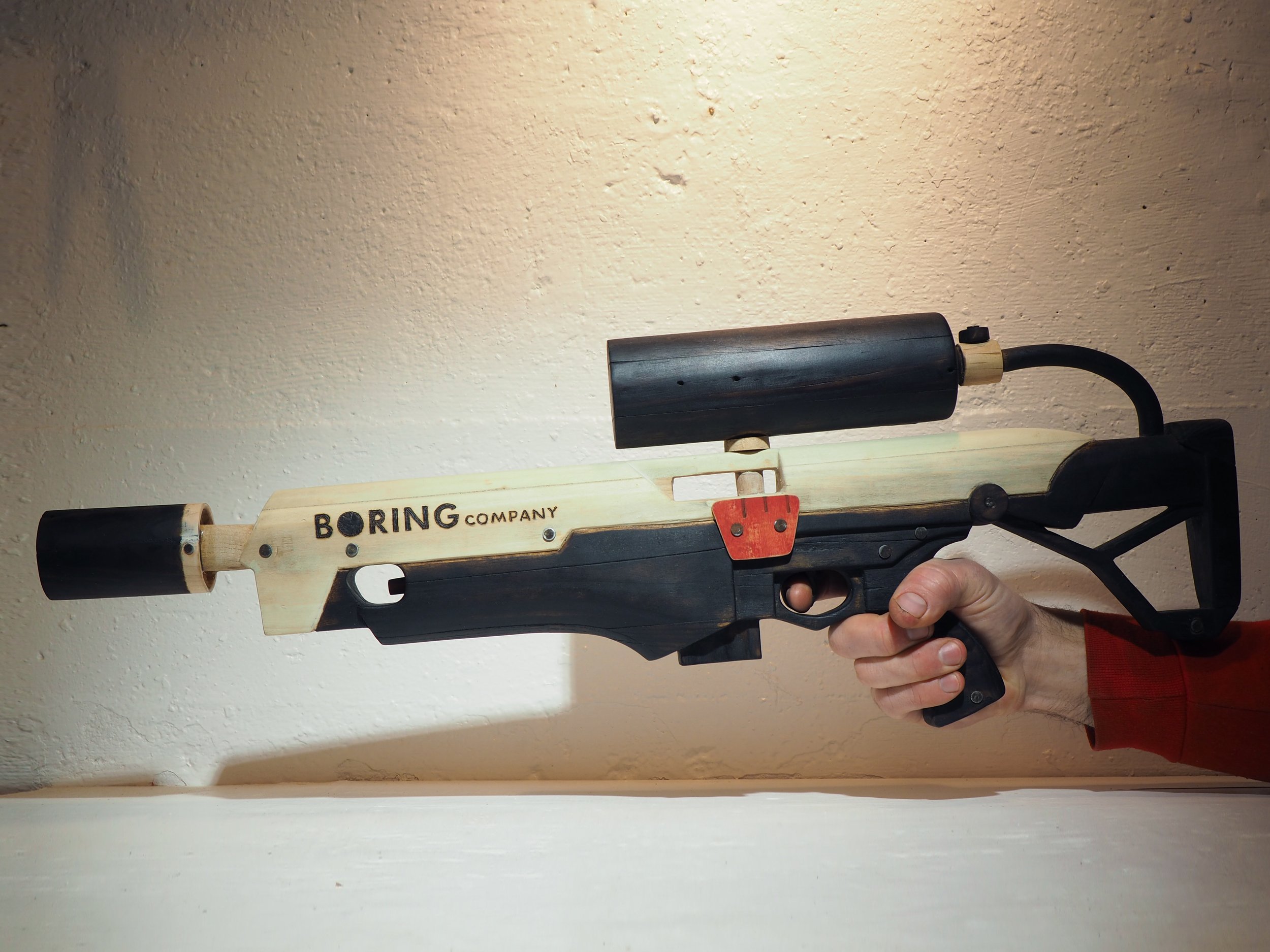 Elon Musk flame thrower Twitter X Tesla corporate culture anti-capitalist woodworking wood sculpture recycled reclaimed pallet wood satire celebrity parody art