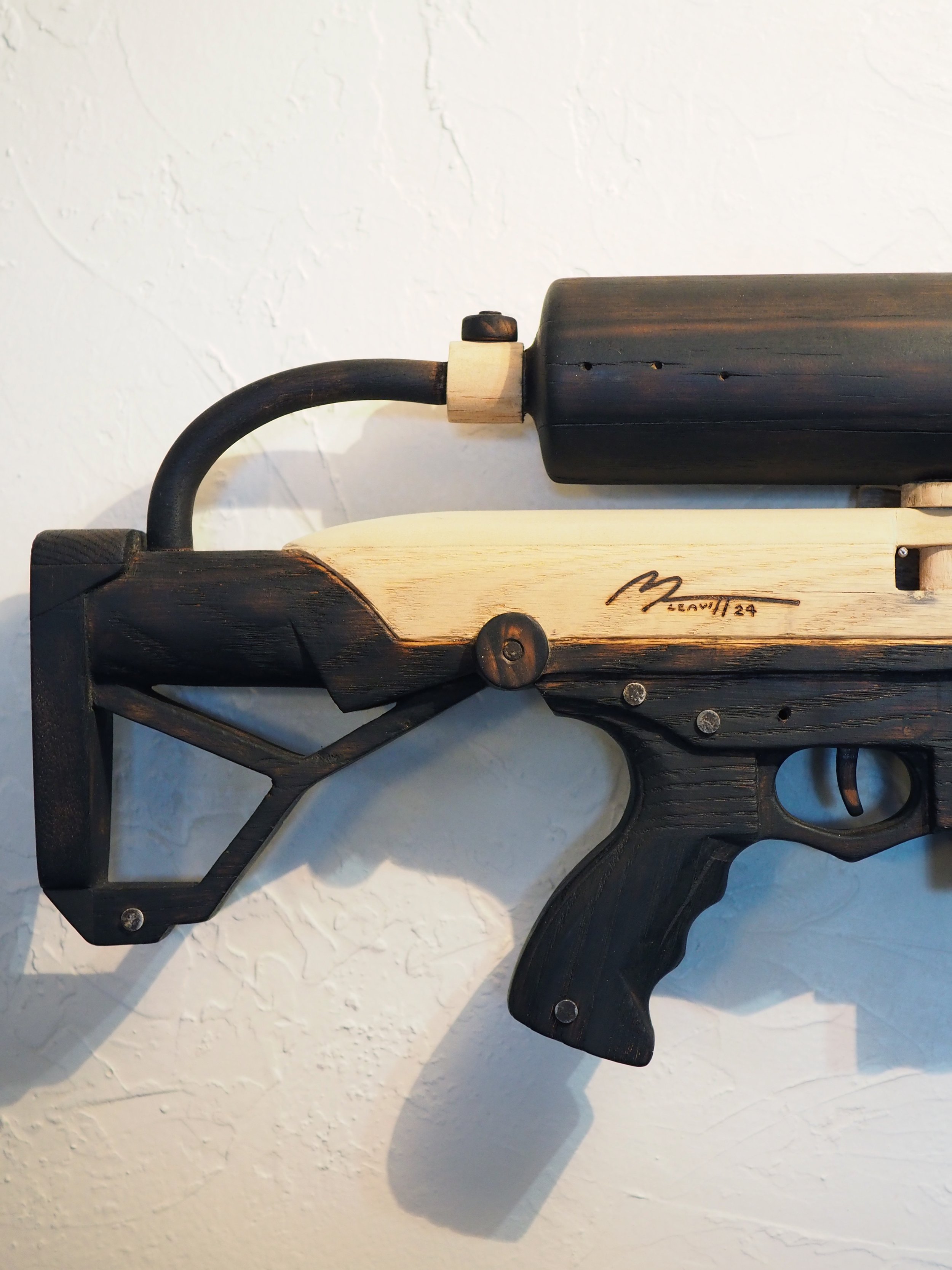 Elon Musk flame thrower Twitter X Tesla corporate culture anti-capitalist woodworking wood sculpture recycled reclaimed pallet wood satire celebrity parody art