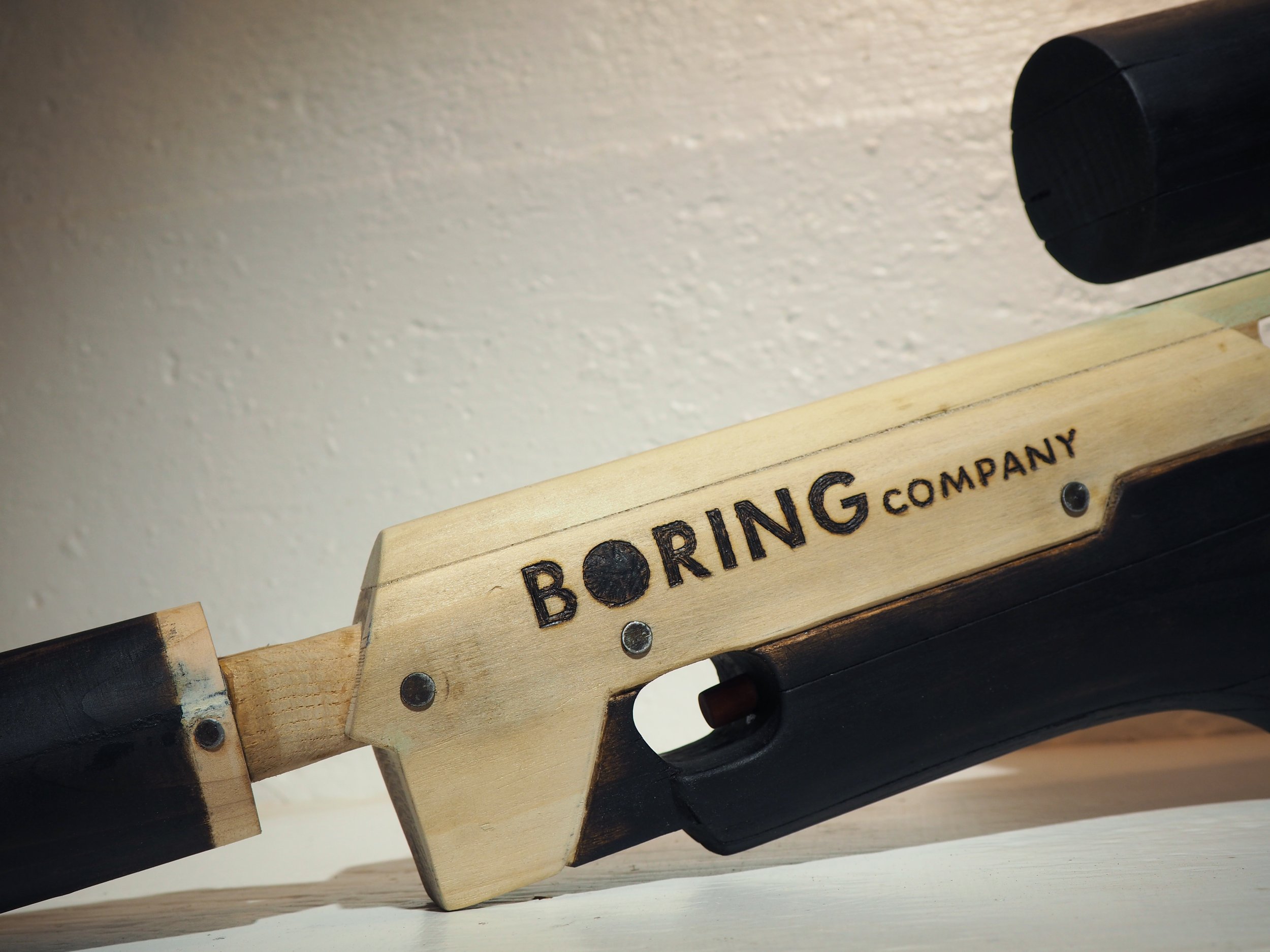 Elon Musk flame thrower Twitter X Tesla corporate culture anti-capitalist woodworking wood sculpture recycled reclaimed pallet wood satire celebrity parody art