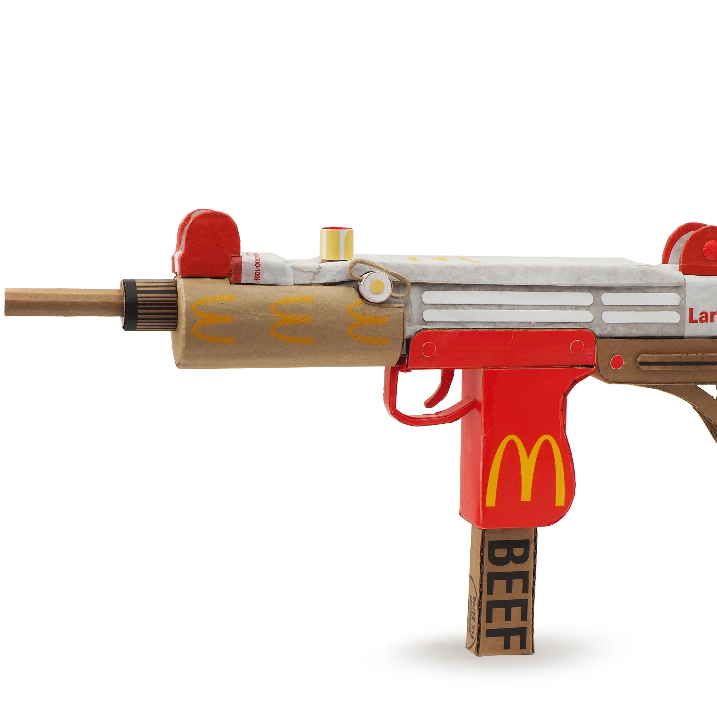 Mass shooting cardboard Uzi recycled material art sculpture political action McDonalds corporate culture parody