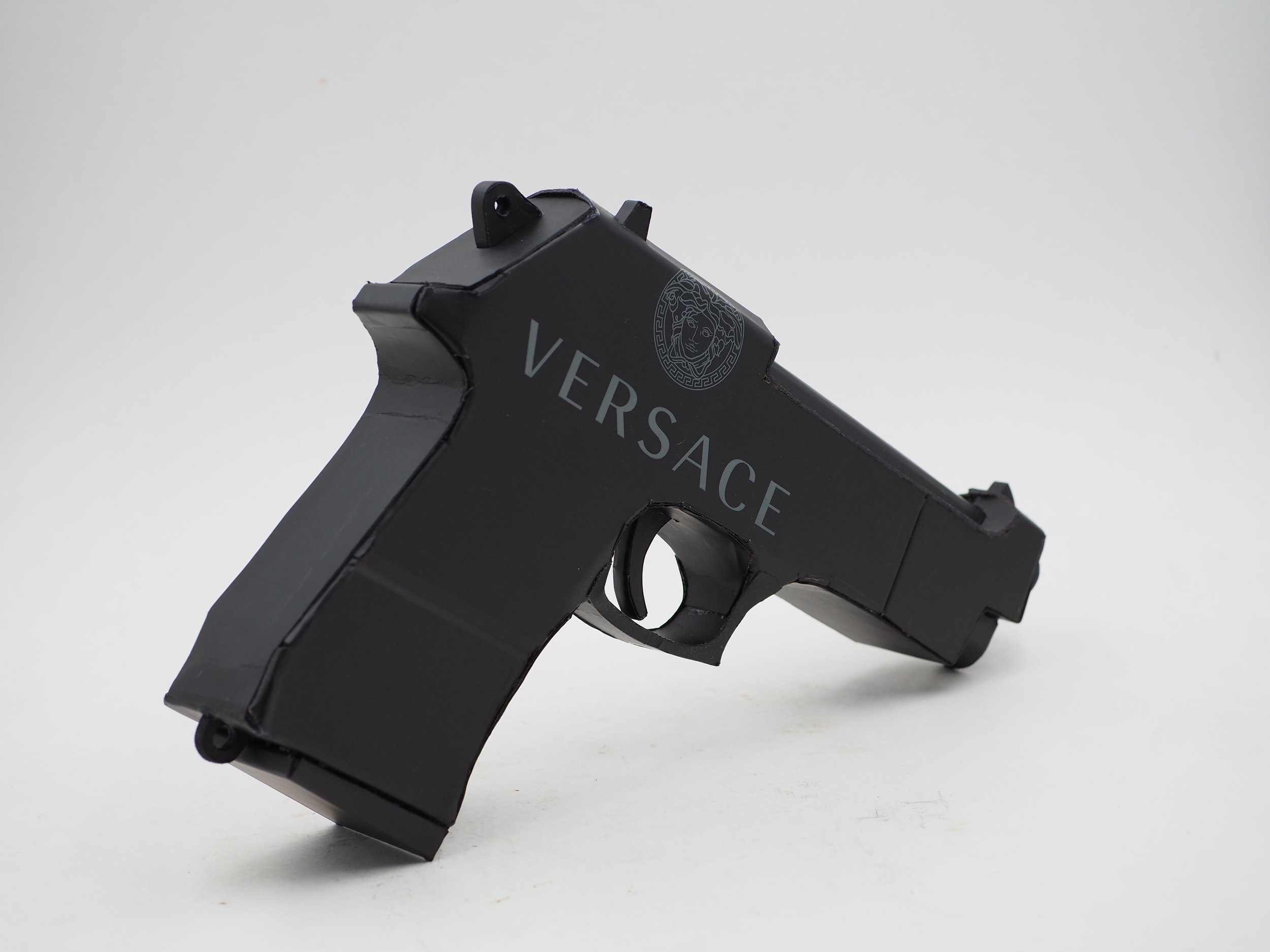 Versace Beretta pistol Italy recycled cardboard waste packaging high fashion luxury brand comedy satire parody lampoon art sculpture