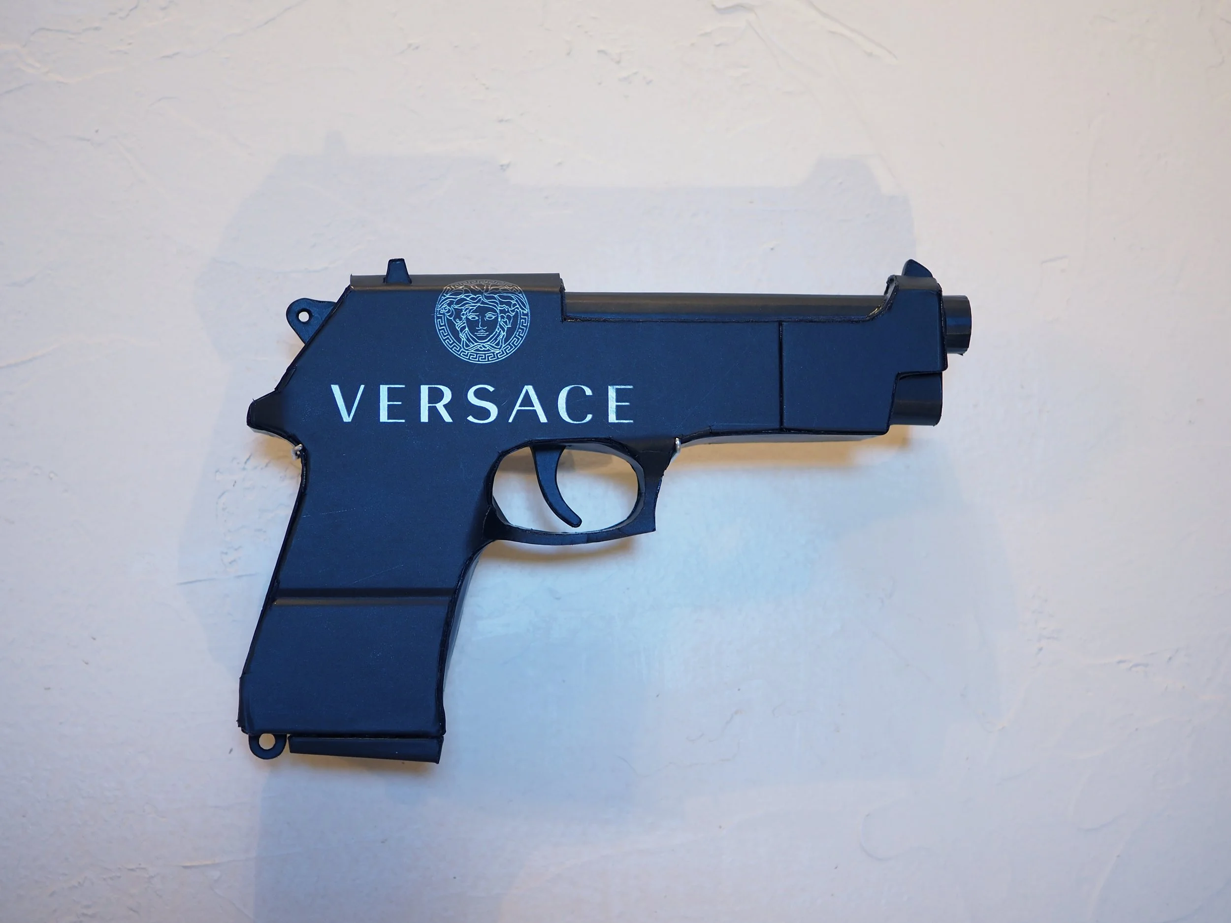 Versace Beretta pistol Italy recycled cardboard waste packaging high fashion luxury brand comedy satire parody lampoon art sculpture