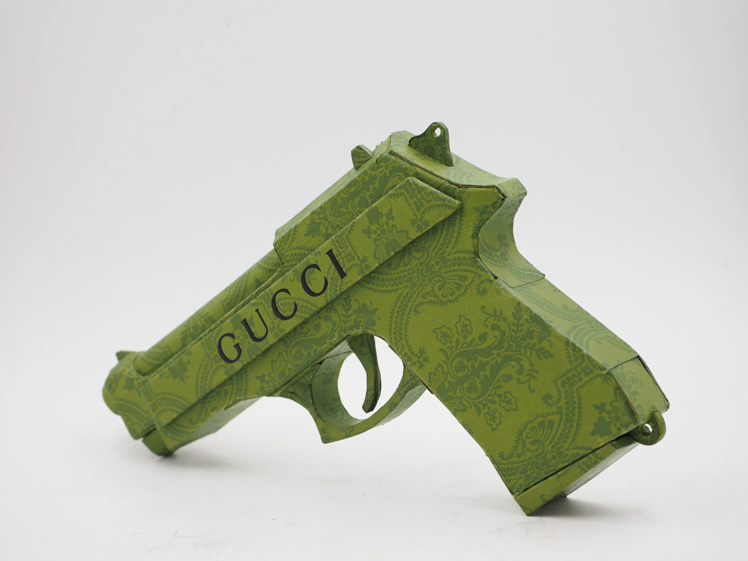 Gucci Beretta pistol Italy recycled cardboard waste packaging high fashion luxury brand comedy satire parody lampoon art sculpture