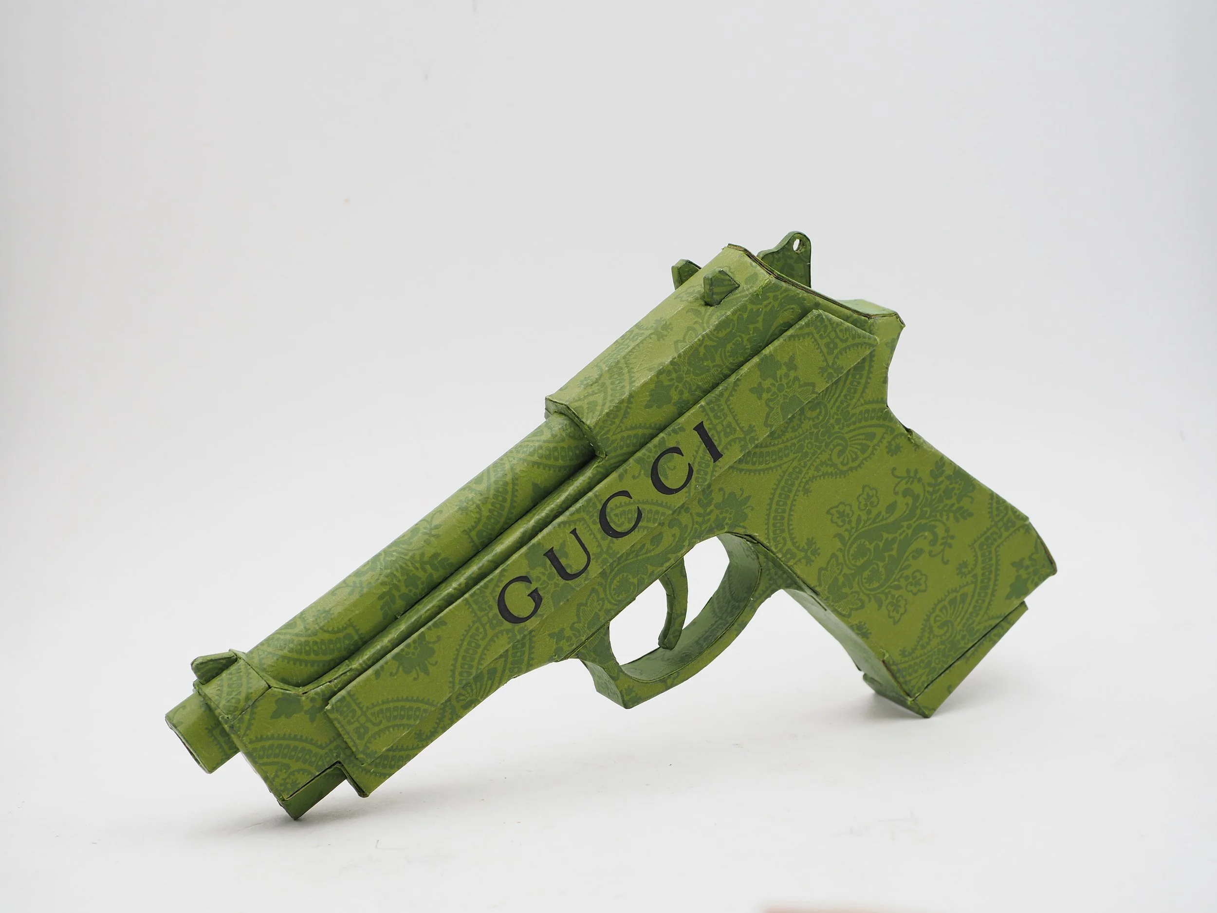 Gucci Beretta pistol Italy recycled cardboard waste packaging high fashion luxury brand comedy satire parody lampoon art sculpture