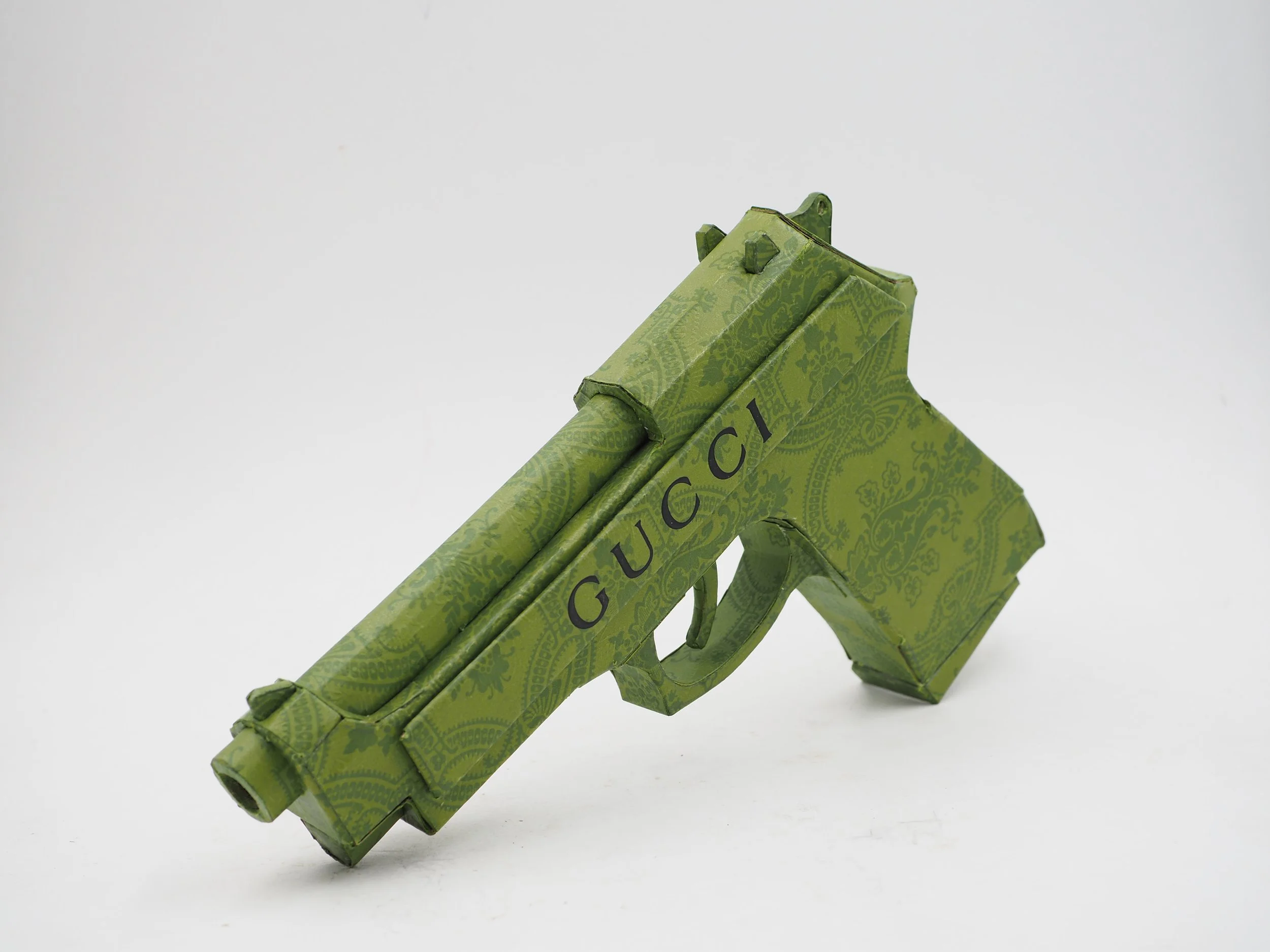 Gucci Beretta pistol Italy recycled cardboard waste packaging high fashion luxury brand comedy satire parody lampoon art sculpture