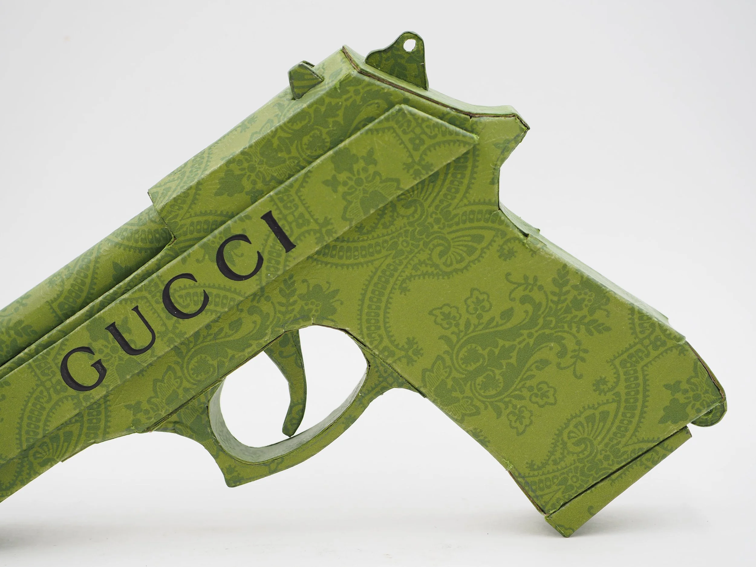 Gucci Beretta pistol Italy recycled cardboard waste packaging high fashion luxury brand comedy satire parody lampoon art sculpture