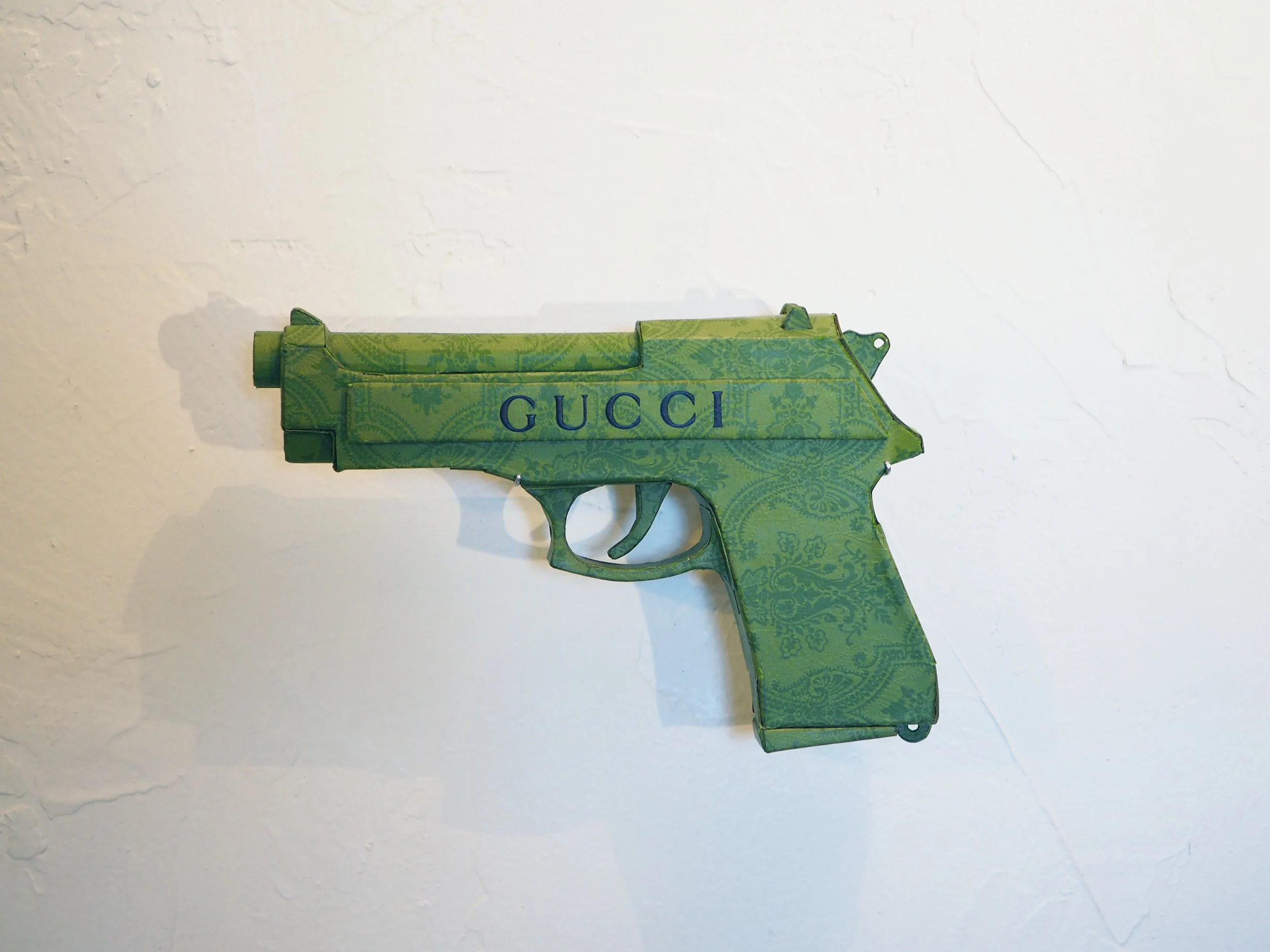 Gucci Beretta pistol Italy recycled cardboard waste packaging high fashion luxury brand comedy satire parody lampoon art sculpture