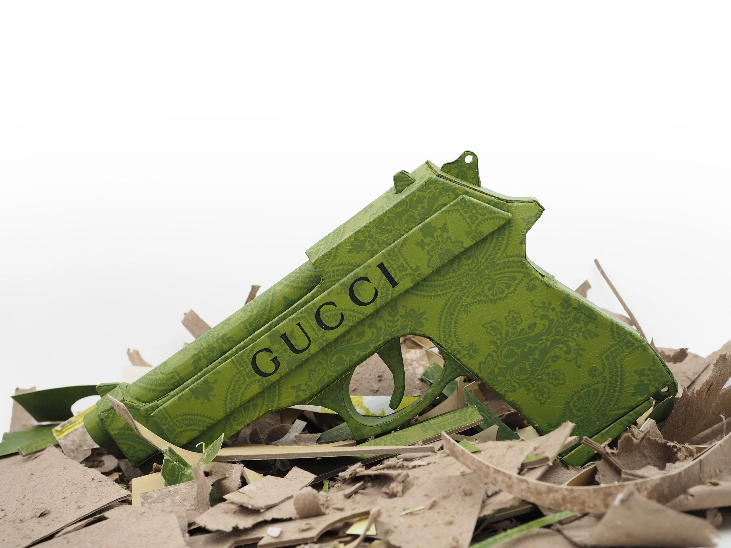 Gucci Beretta pistol Italy recycled cardboard waste packaging high fashion luxury brand comedy satire parody lampoon art sculpture