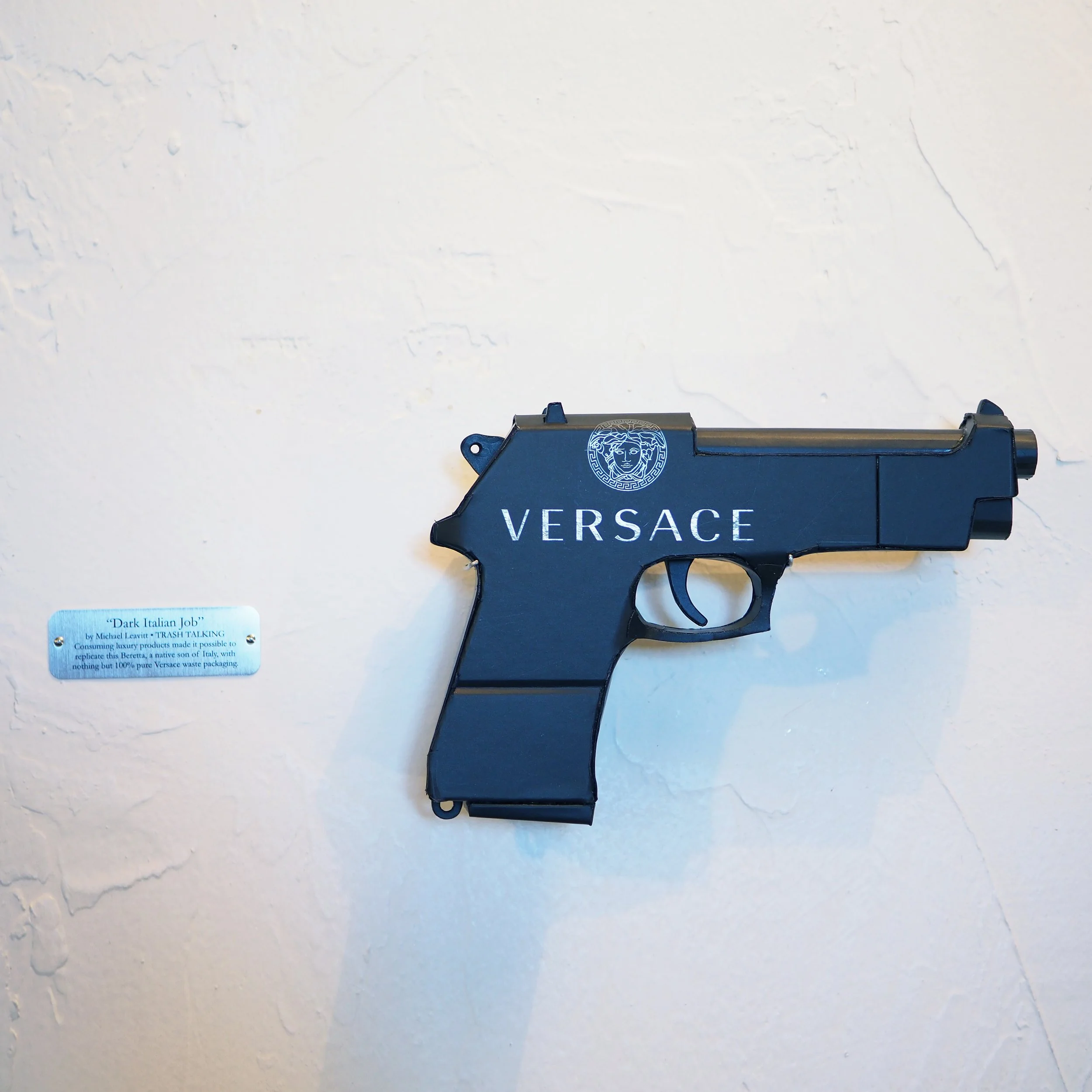 Versace Beretta black pistol Italy recycled cardboard waste packaging high fashion luxury brand comedy satire parody lampoon art sculpture