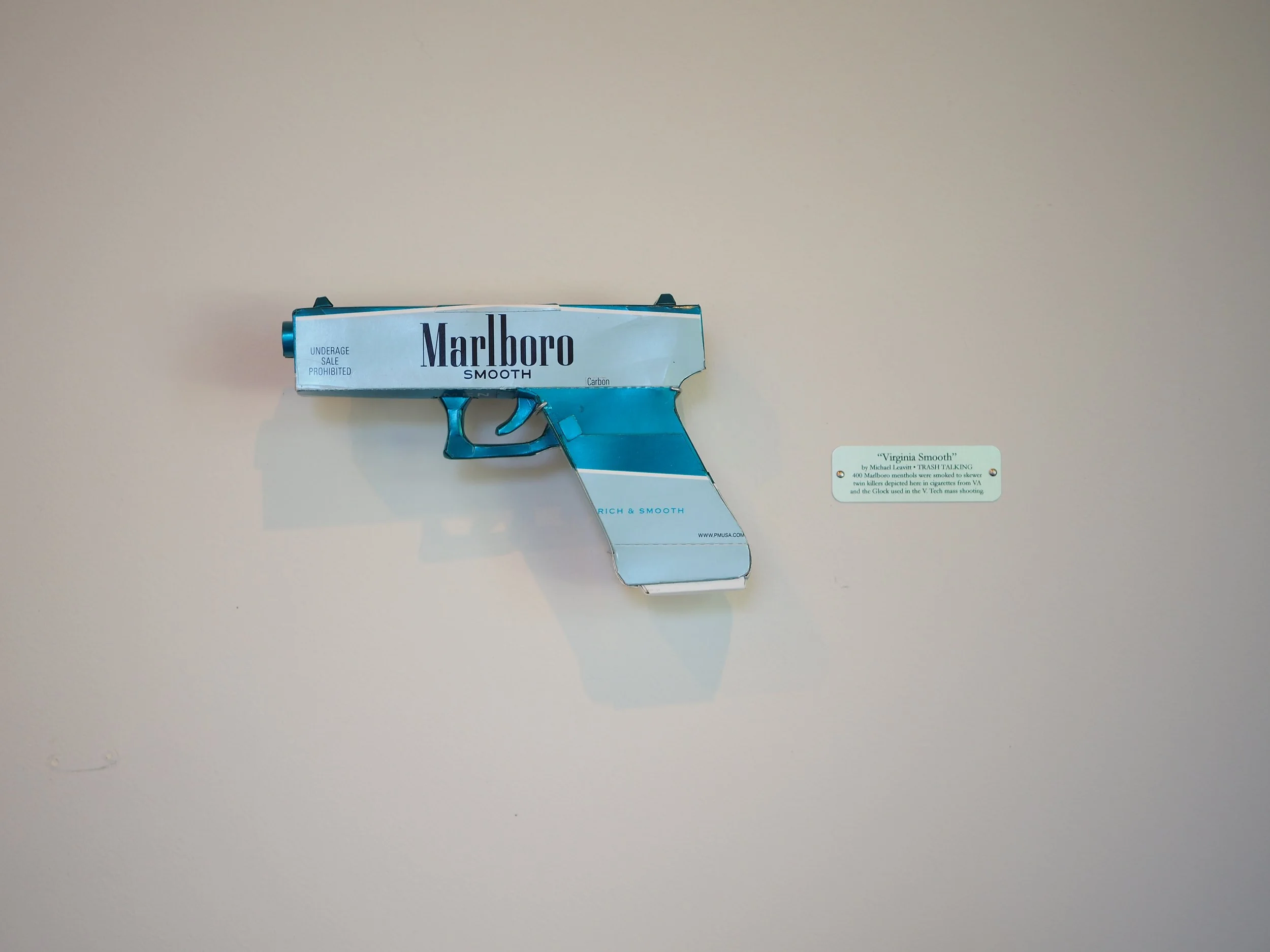 Mass shooting gun violence art sculpture pop culture Marlboro big tobacco satire