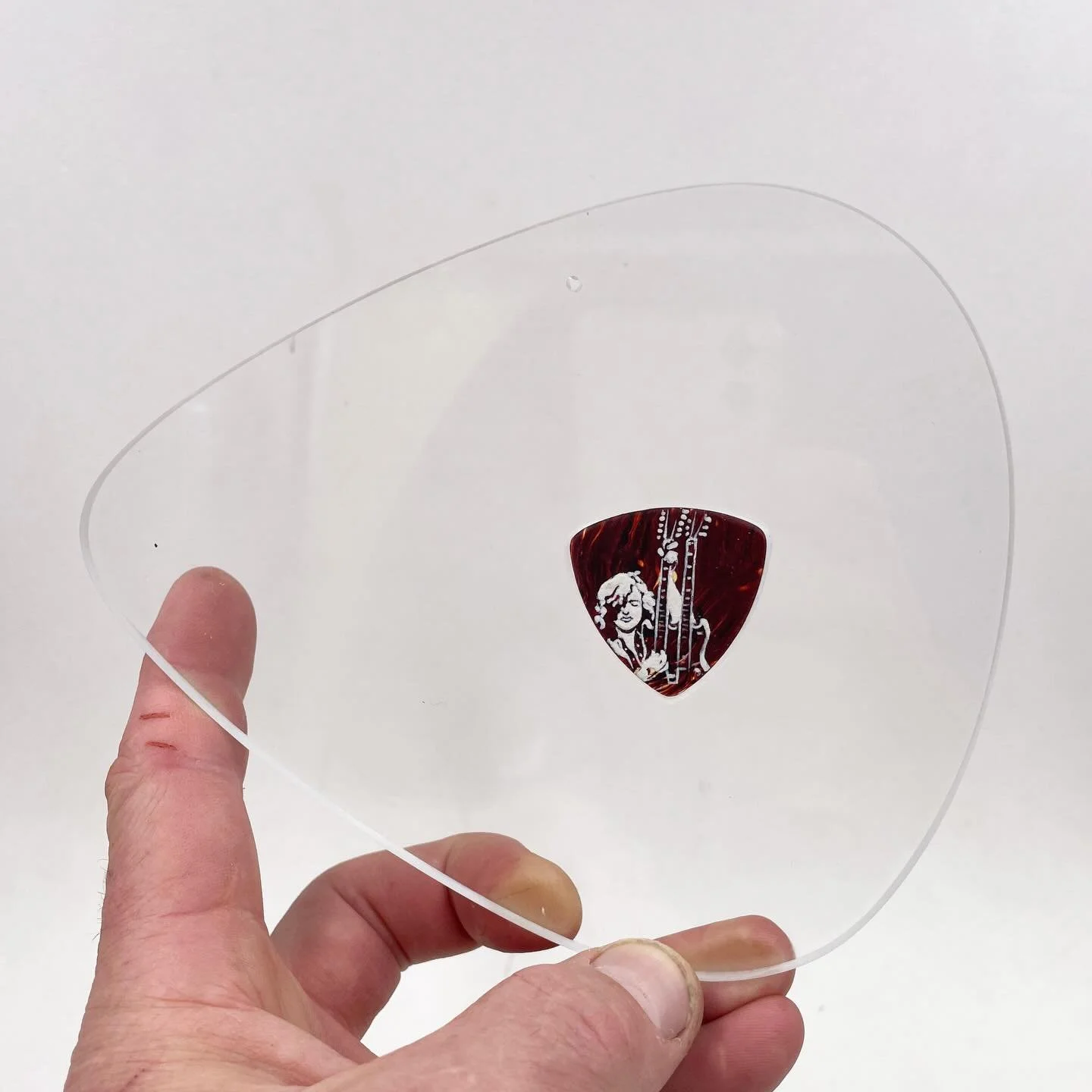 at my link - I made an acrylic pick-shaped frame for this guitar pick, currently up for auction. Check it