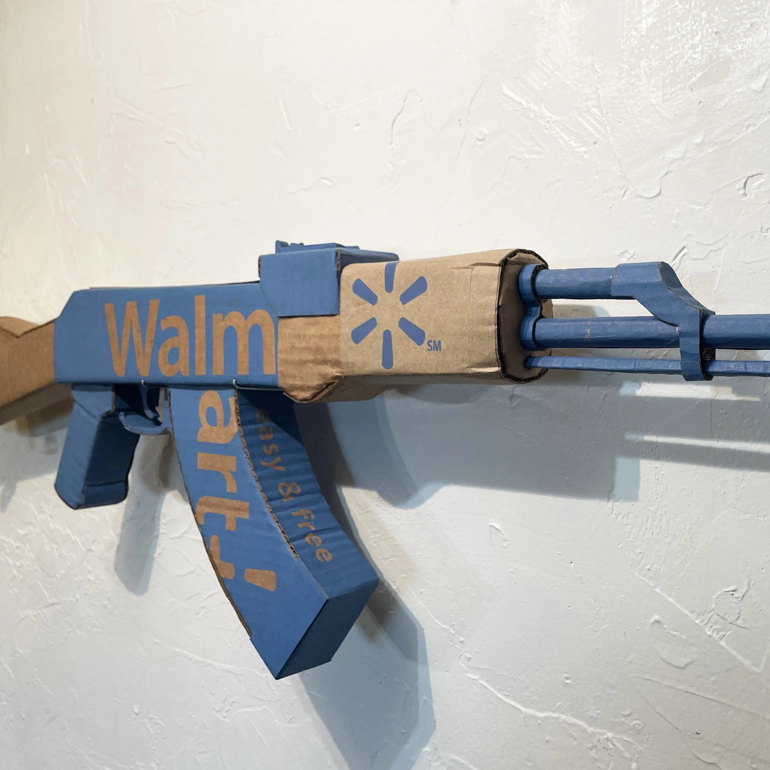 Walmart corporate satire El Paso Texas mass shooting cardboard recycled material art sculpture political action parody