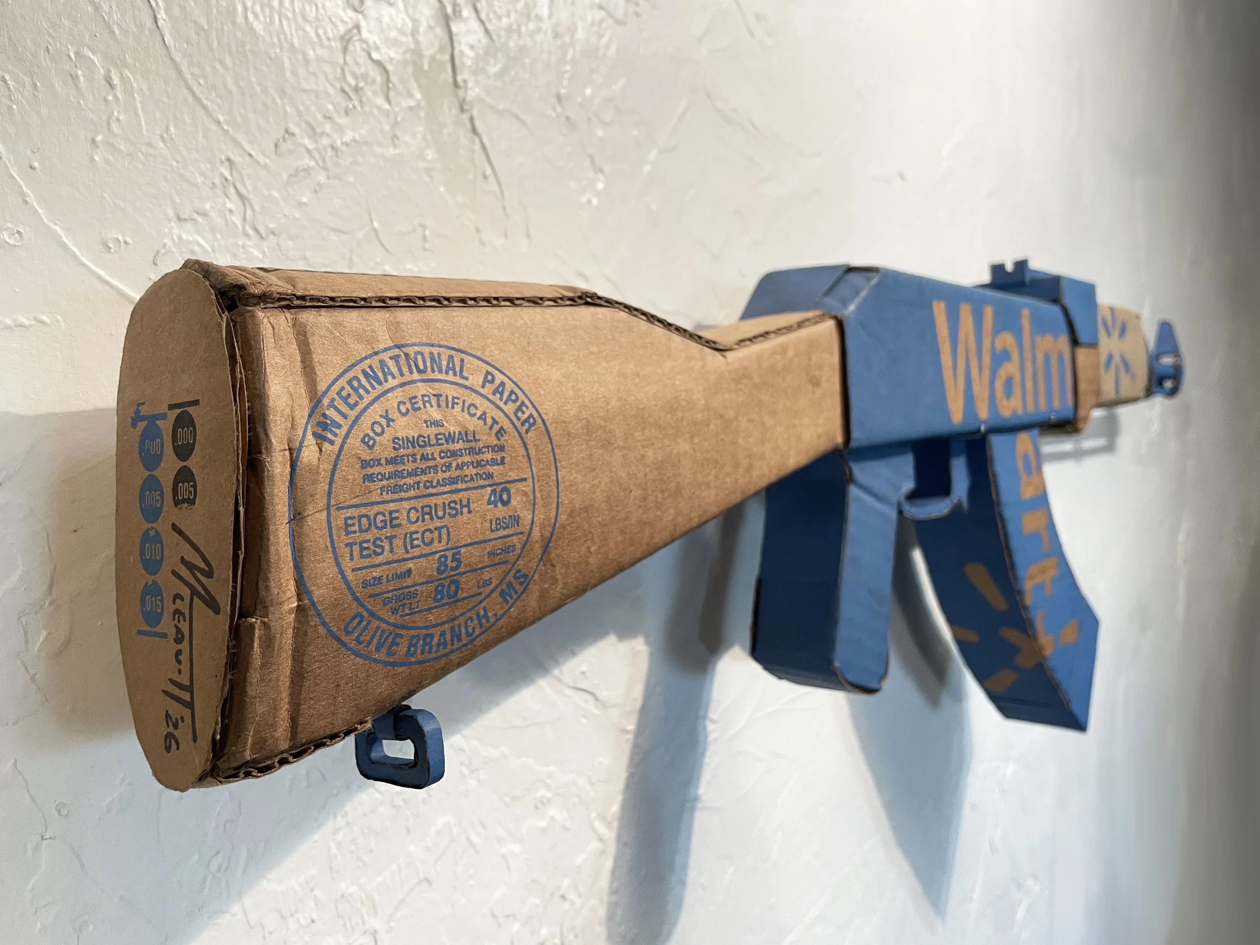 Walmart corporate satire El Paso Texas mass shooting cardboard recycled material art sculpture political action parody