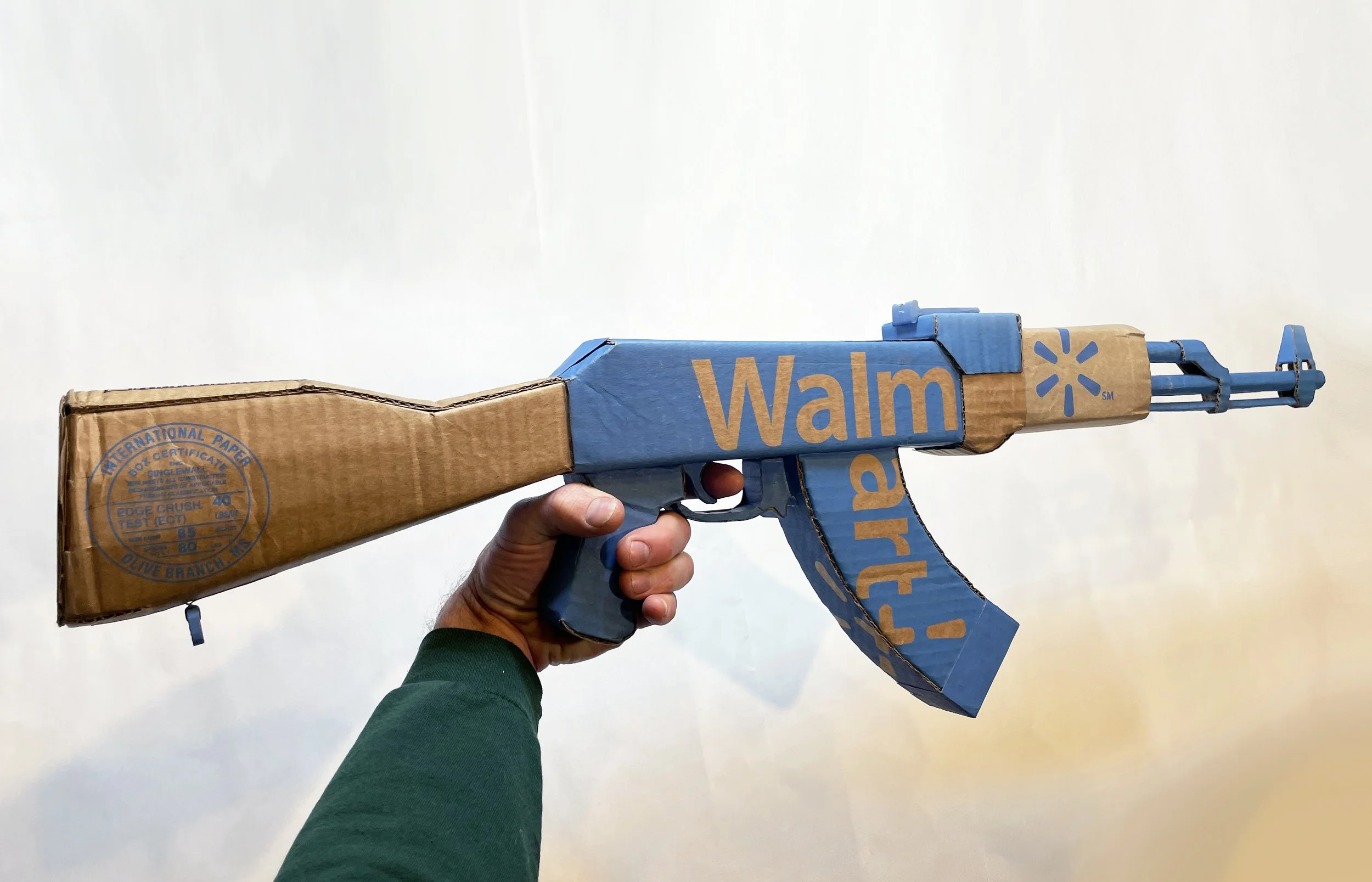 Walmart corporate satire El Paso Texas mass shooting cardboard recycled material art sculpture political action parody