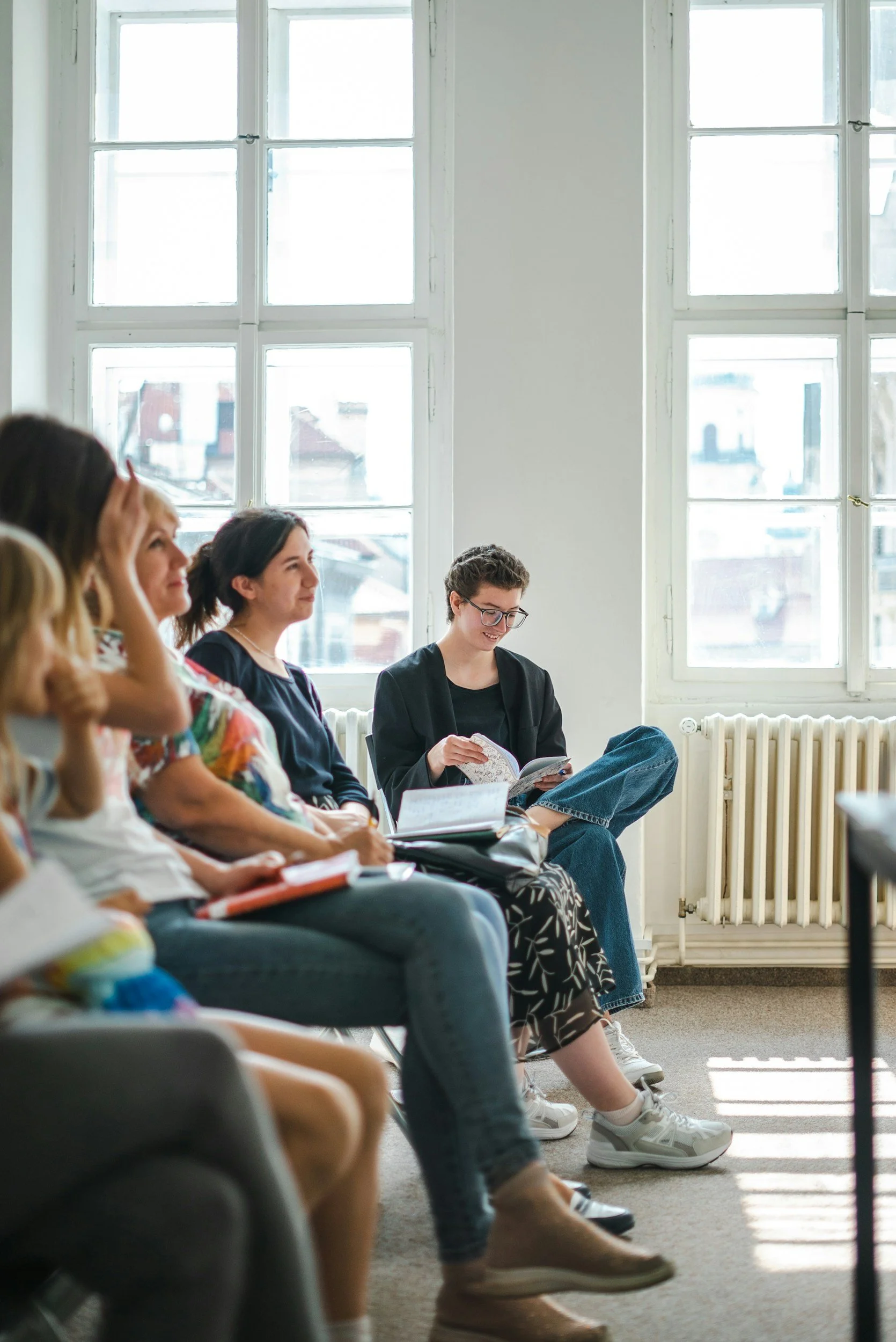 A group of women sitting in a room with notebooks