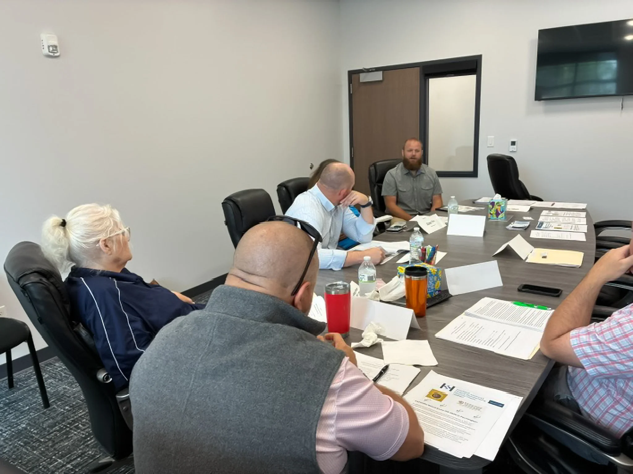  Grant recipient Dave Cross of Precision Injection Molding of Tahlequah (middle, back) explains his operation to the Board on June 26 in Stilwell; he has hired 12 employees and plans to expand as his market grows. 