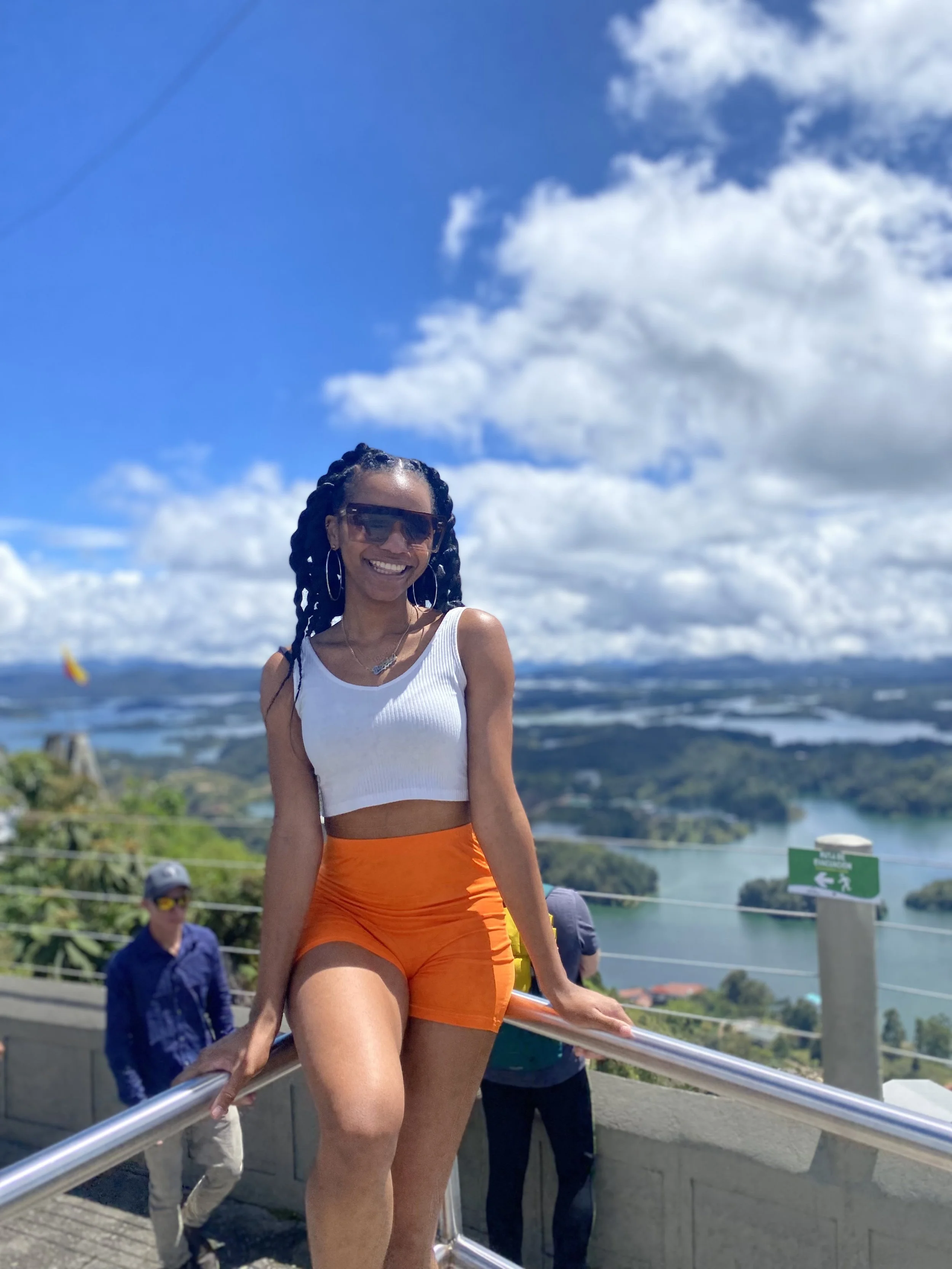 A black girl in front of a beautiful landscape at El Peñól de Guatapé