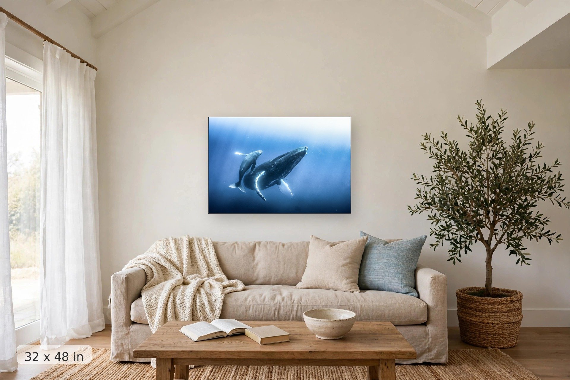 humpback whale calf dancing around its mother — Keiki Kohola print, 32x48 mockup above a living room sofa