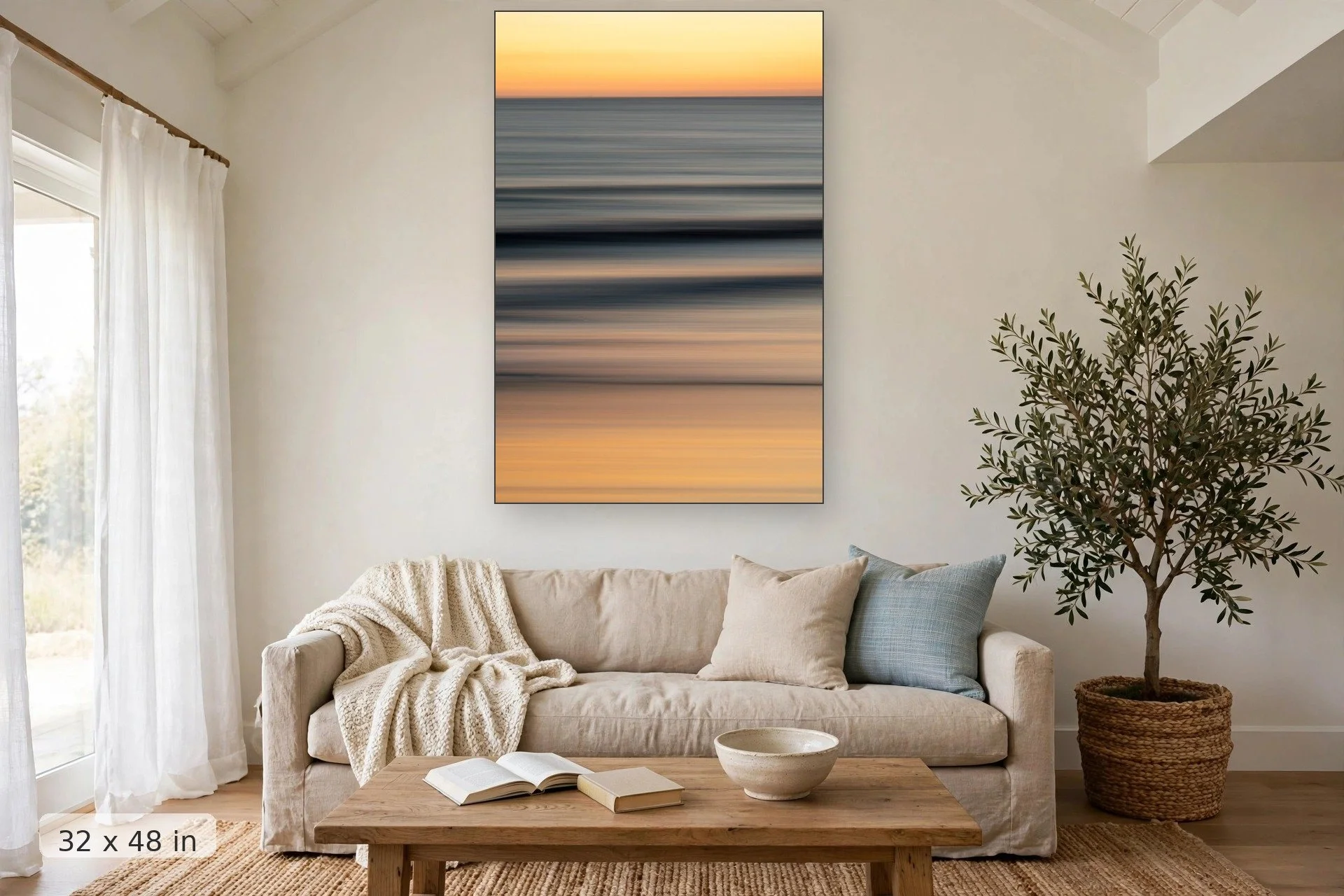Long exposure photograph of sunset on soft rolling tide during golden hour — Soft Glow print, 32x48 mockup above a living room sofa