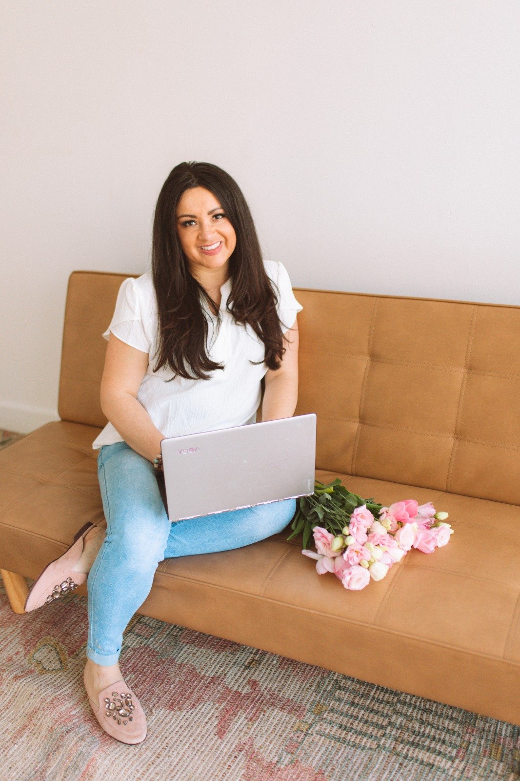Rebecca Jancic with her laptop on a tan couch