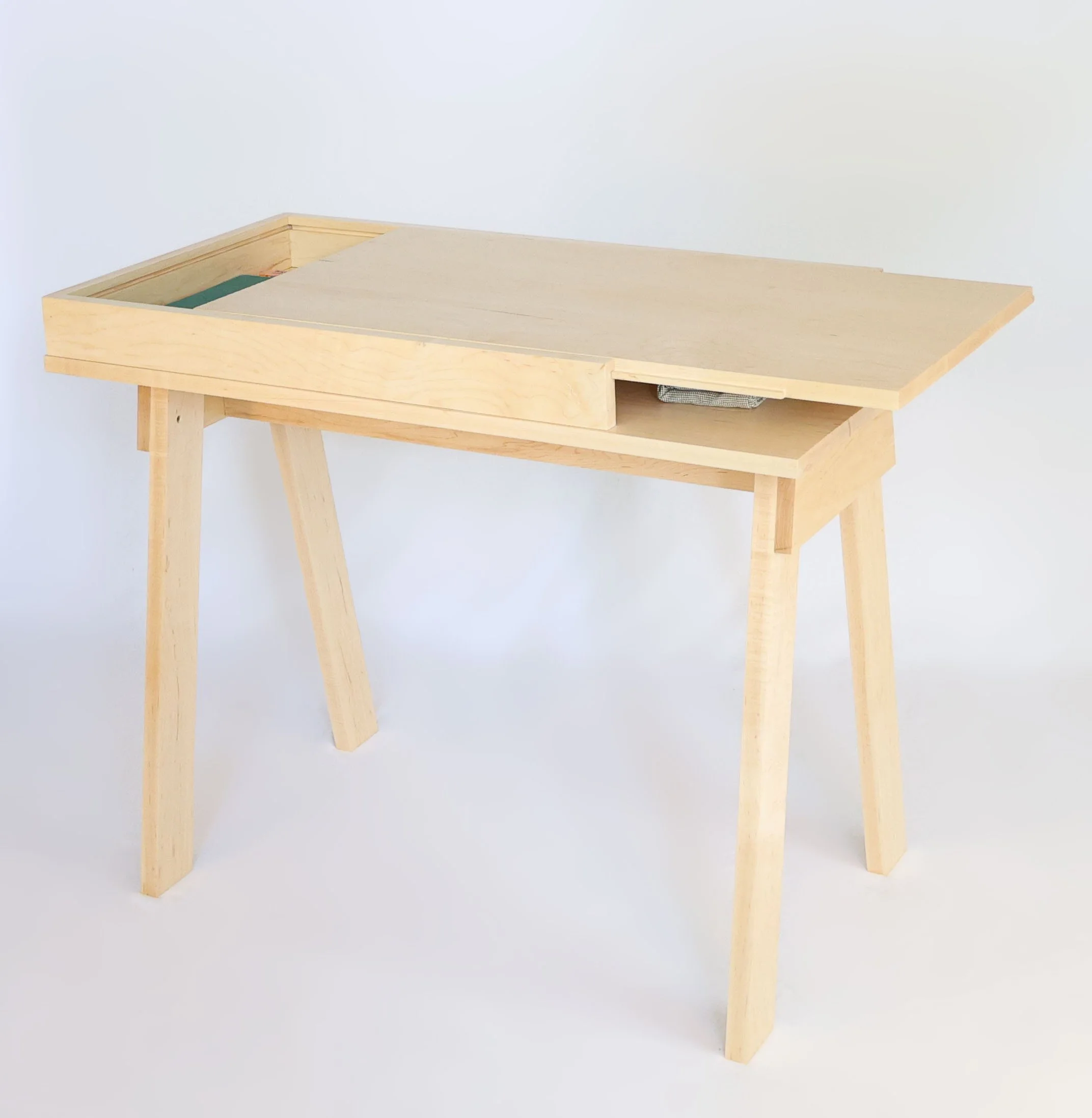 I designed this desk with a sliding top, built it with maple and finished with shellac and wax