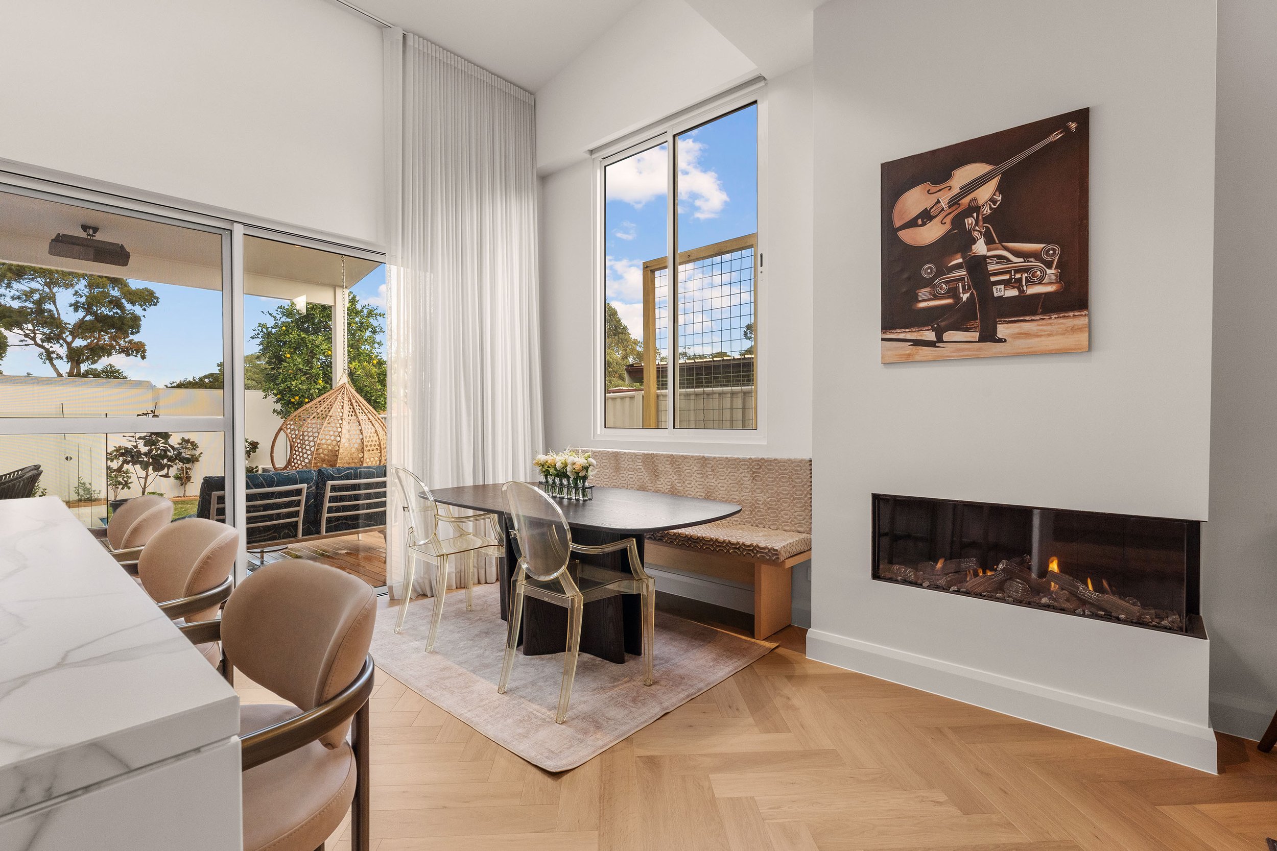 A light-filled dining space designed for everyday family life, with a fireplace adding warmth and connection.