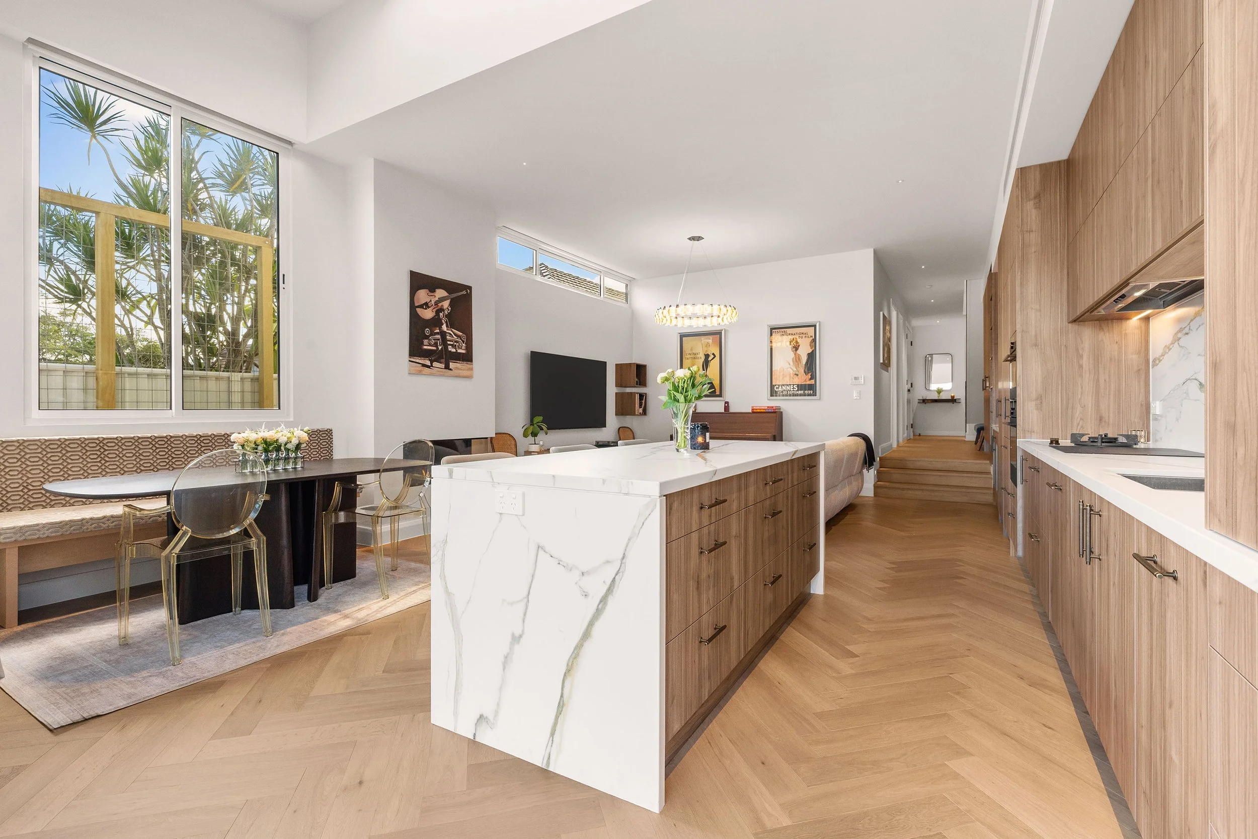 Warm timber joinery, a generous kitchen island and herringbone flooring create a kitchen that feels contemporary while complementing the home's original character.