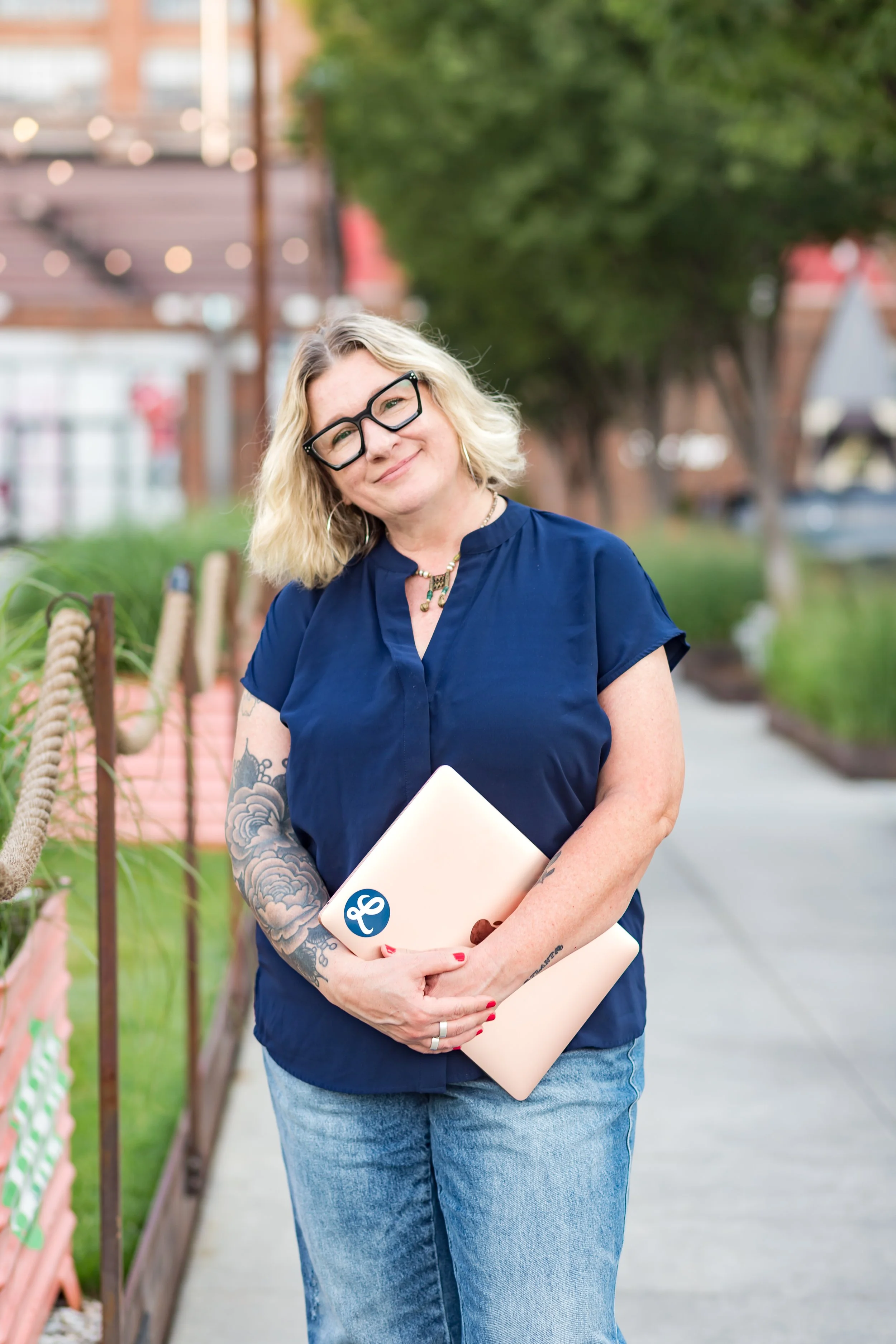 Email marketing expert Lib Aubuchon holding a rose gold laptop in Atlanta, Georgia.