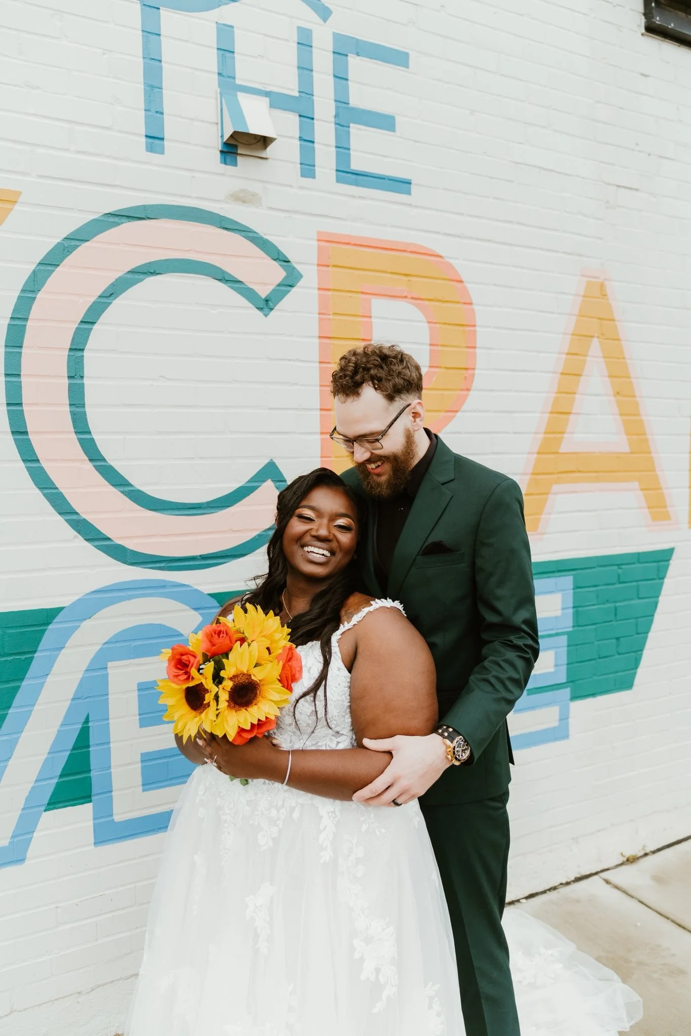 Bride and groom in front of the Haycraft mural