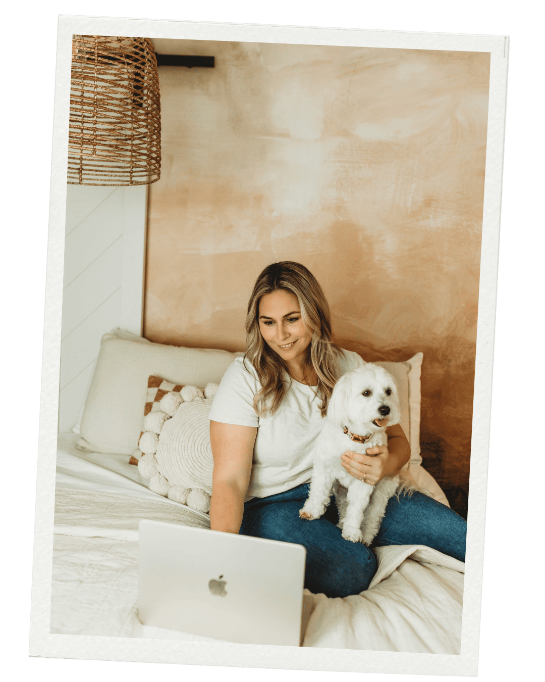 Megan and Lily sitting on a bed with a laptop smling