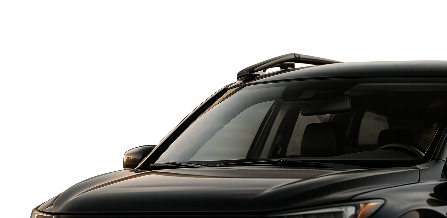 Close-up of a black SUV showing the front left side, windshield, and side mirror, with a dark background.