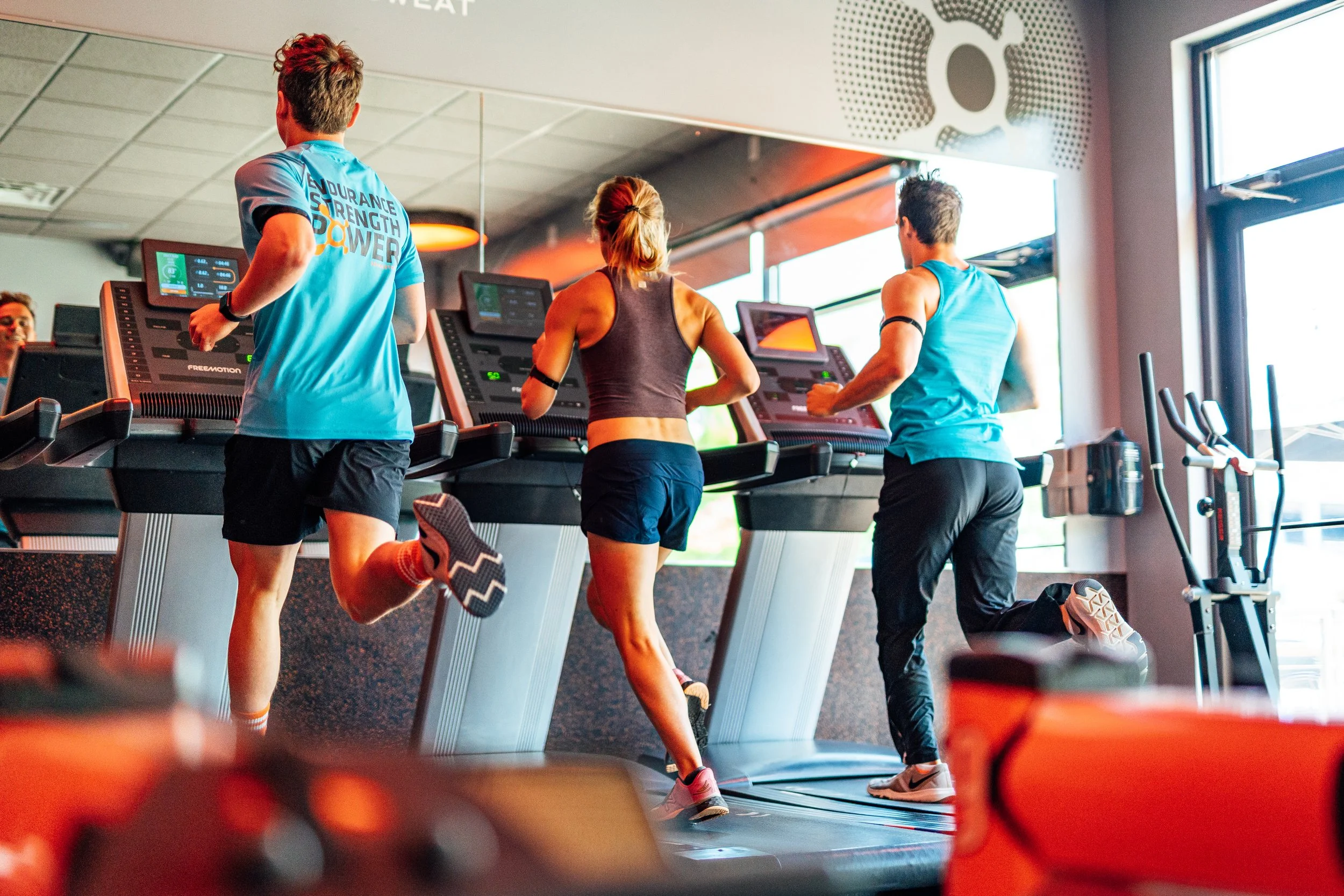 People running on treadmills in a gym.