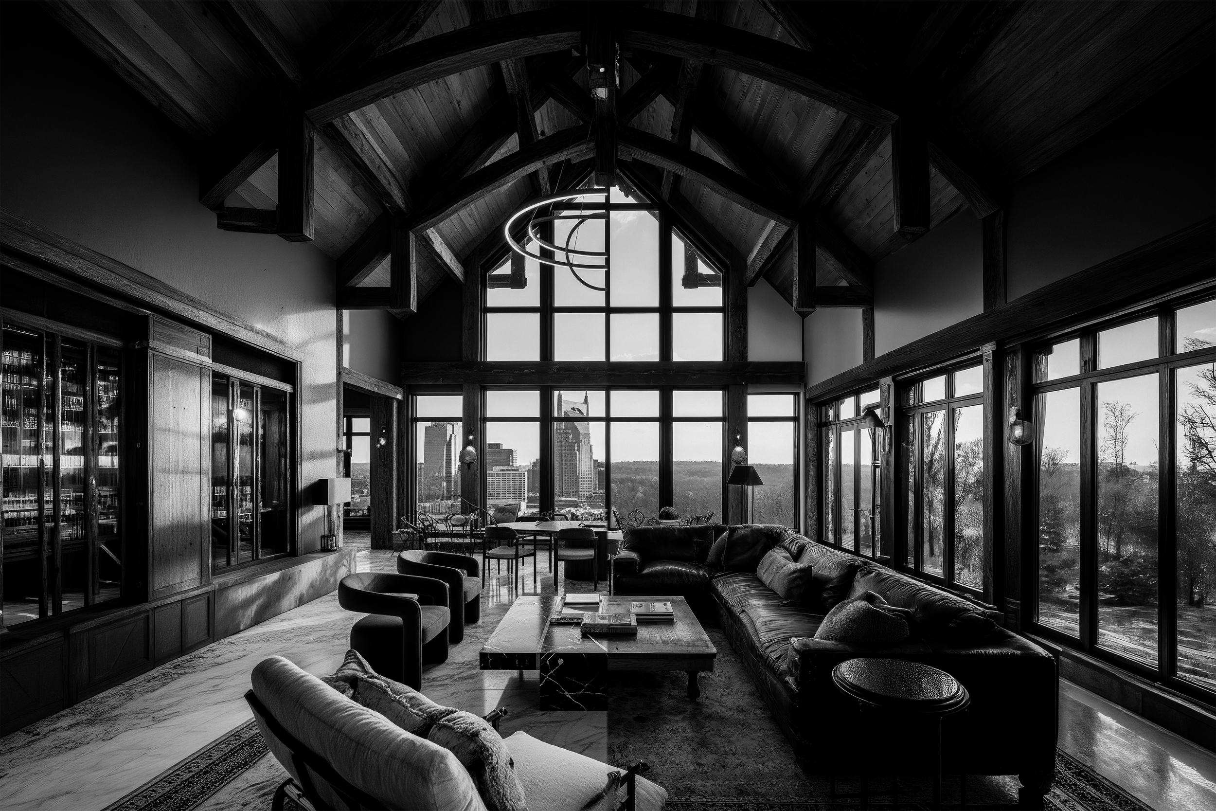 Interior view of a spacious room with large windows, high wooden vaulted ceiling, modern hanging light fixture, and contemporary furniture including sofas and chairs, with city skyline visible outside.