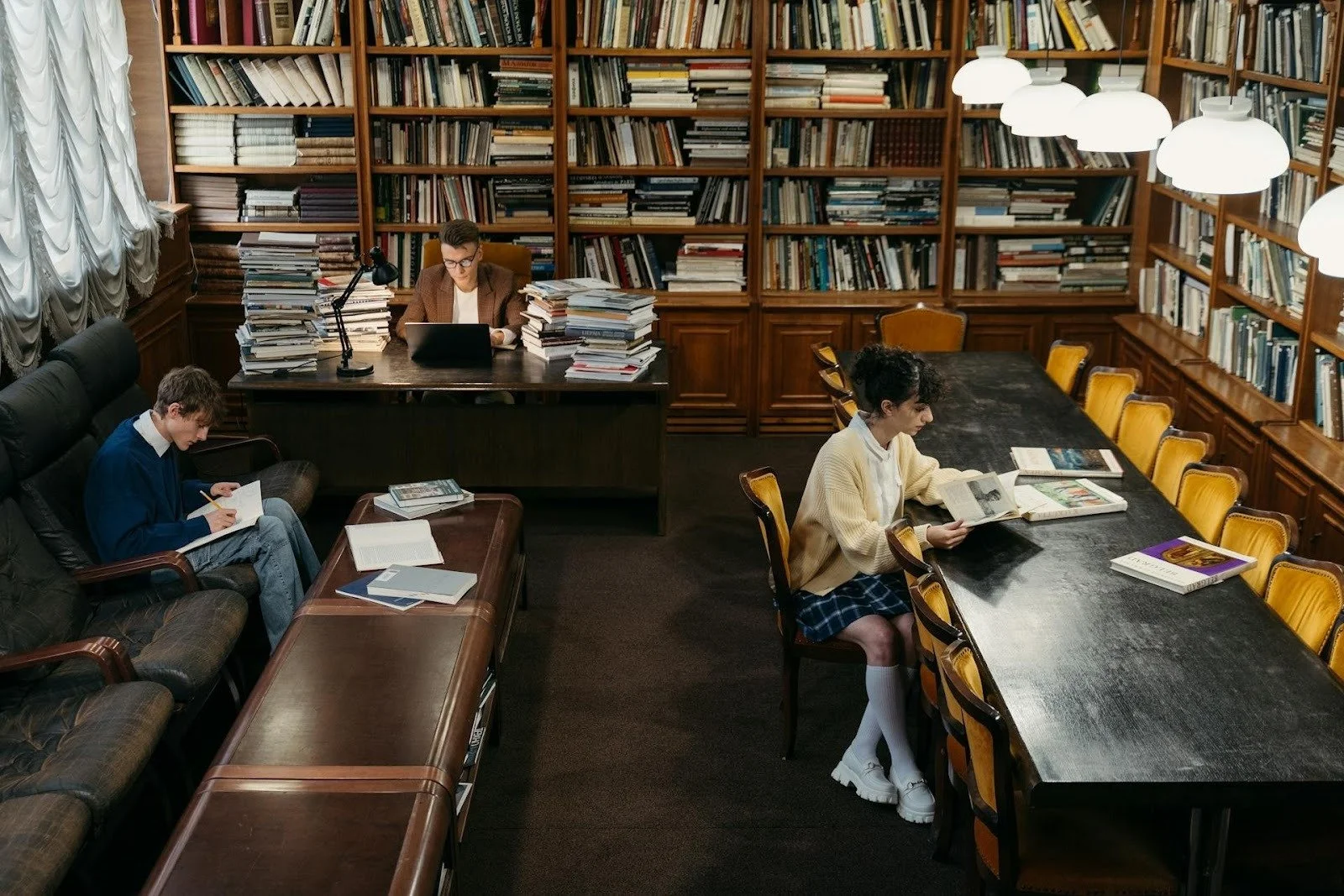 Three students studying in the library.