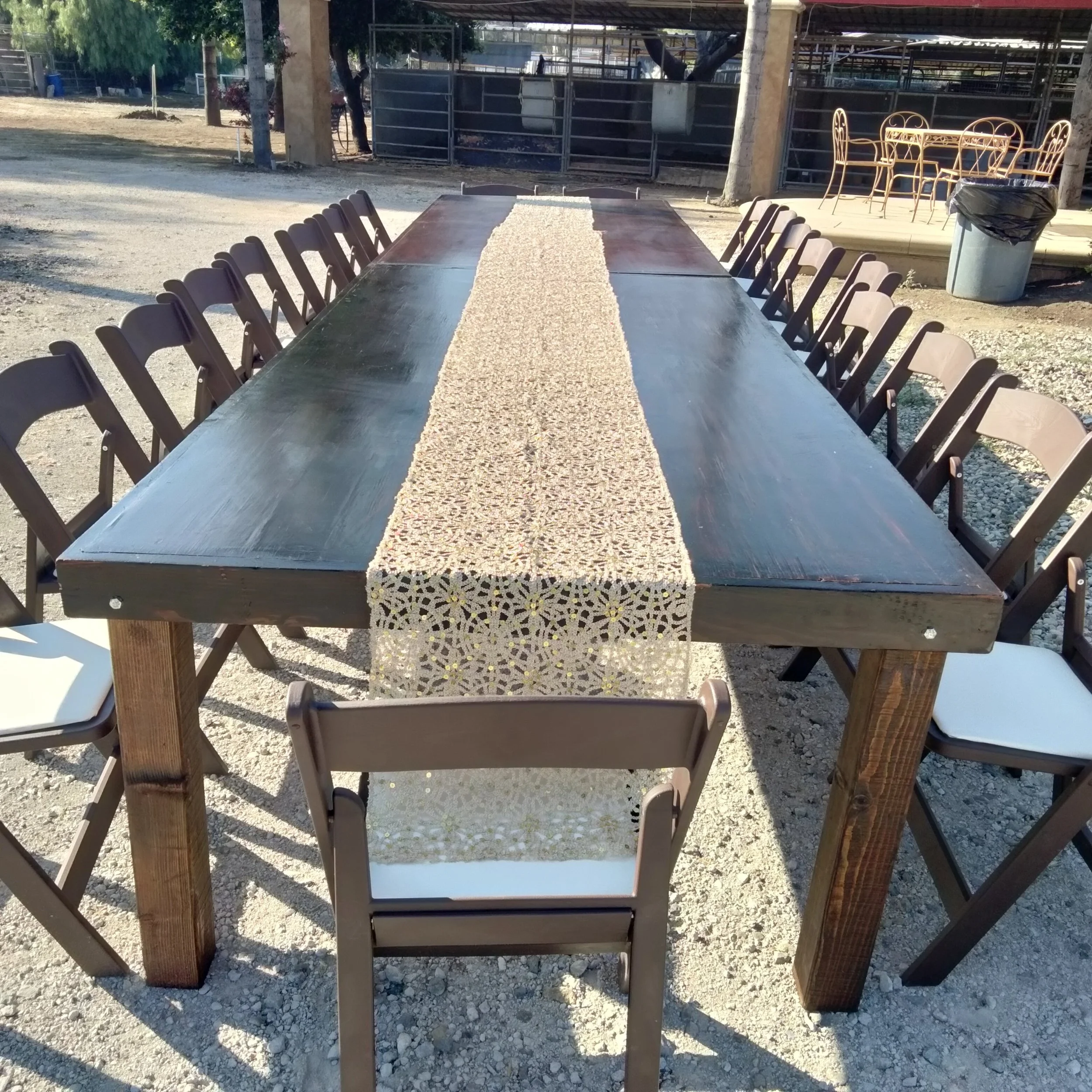 Long wooden table with a beige table runner surrounded by brown folding chairs