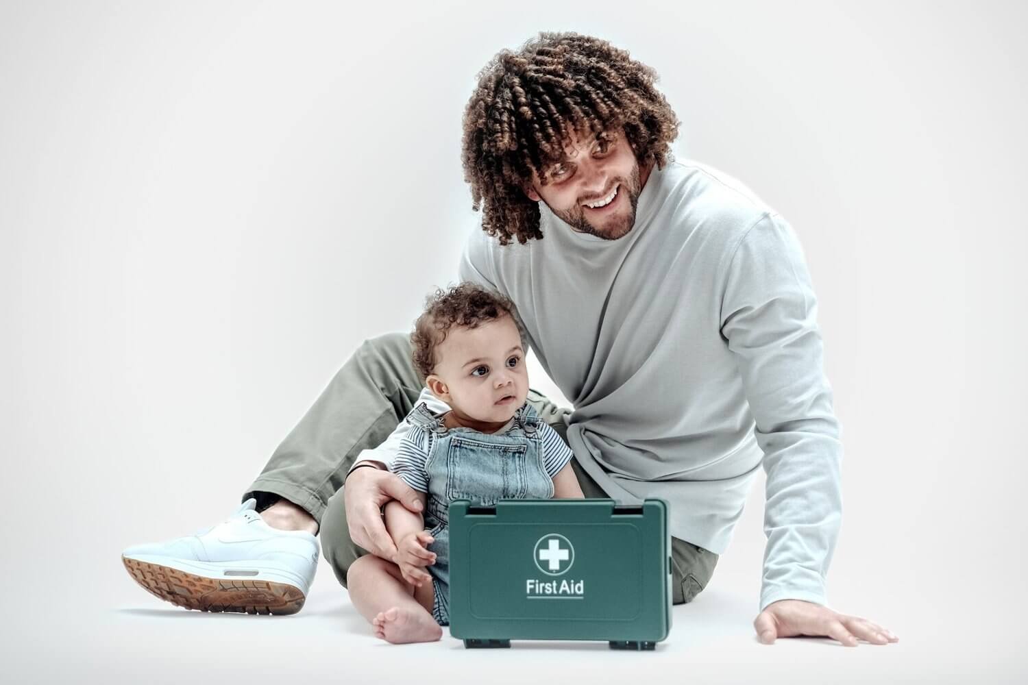 Father and baby with a first aid kit