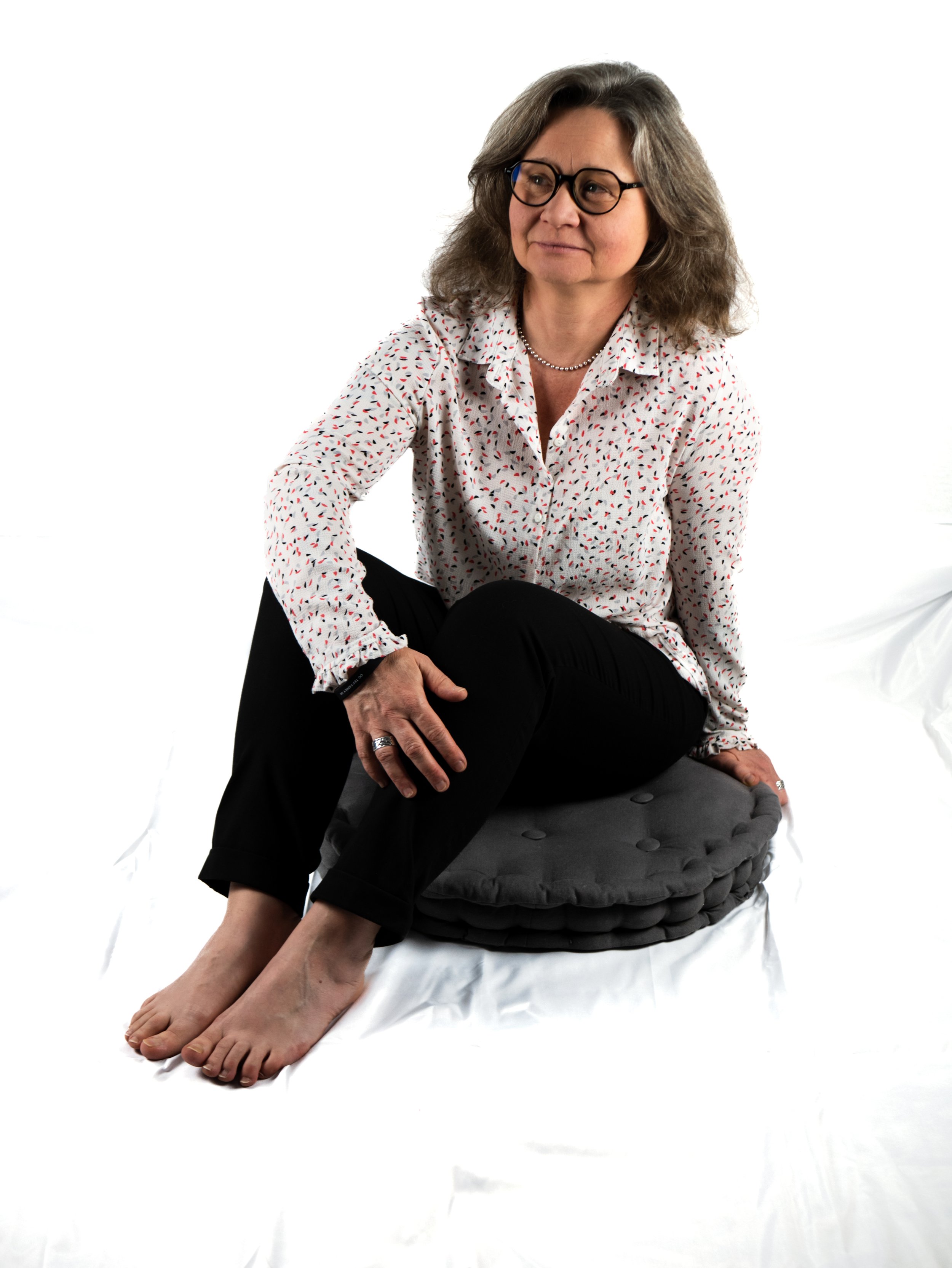 Femme assise sur coussin gris jambe pliées.jpg