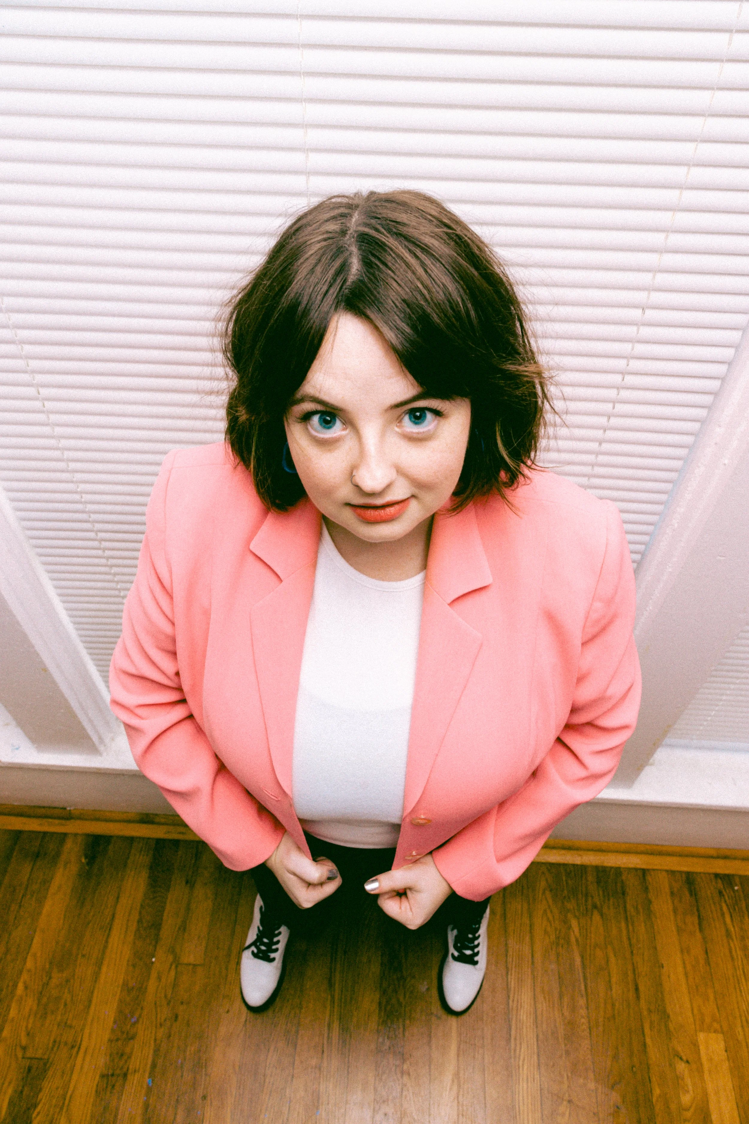 Anna Cutchen stand in front of a window in a pink blazer