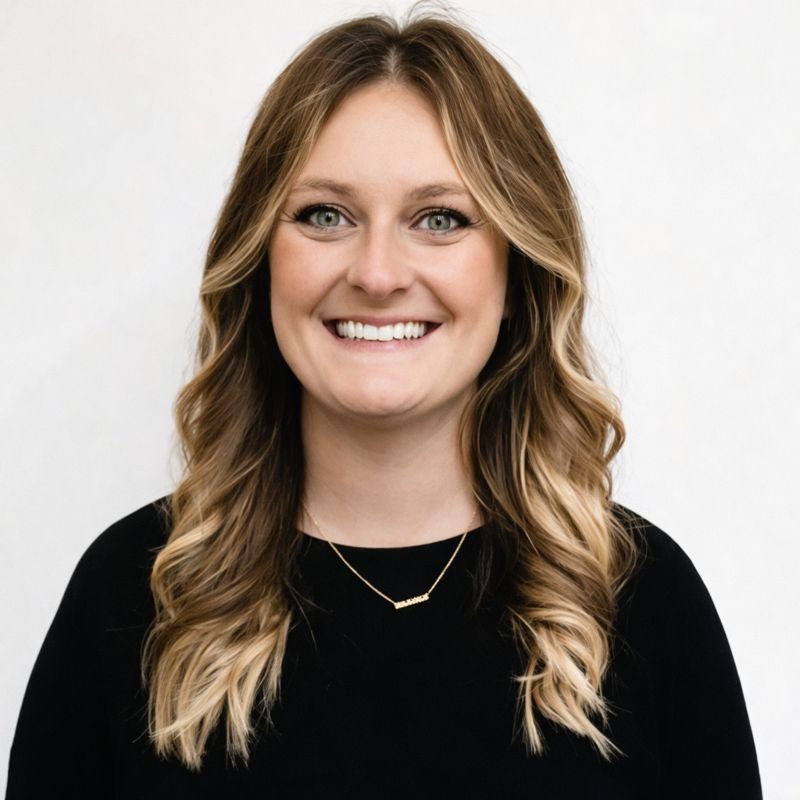 Black and white portrait of a woman with long wavy hair, smiling.
