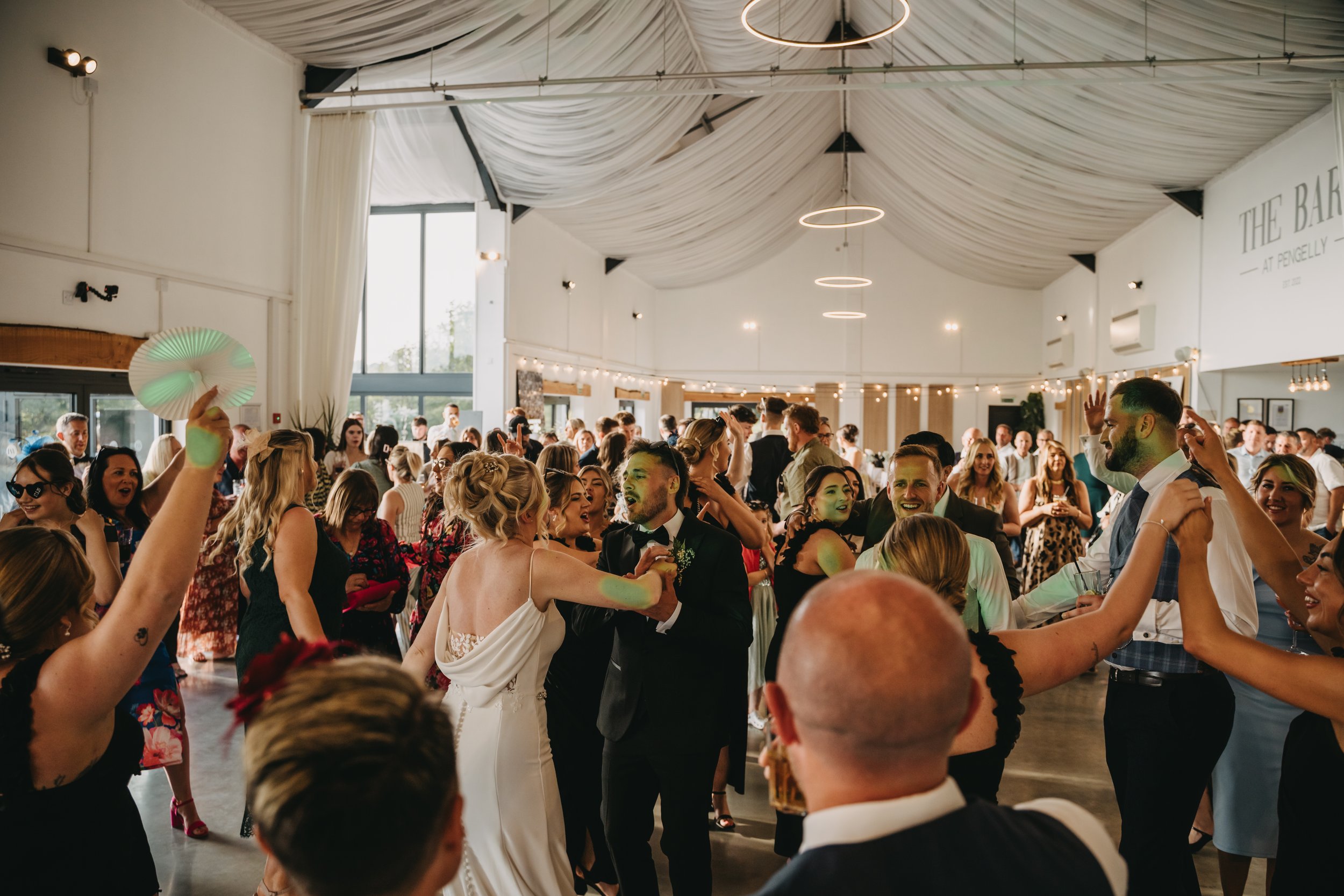 DJ setup at a dimly lit party with guests dancing and blue lighting.