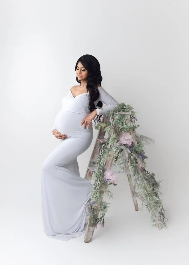 Maternity photo featuring a glowing pregnant lady in long white dress